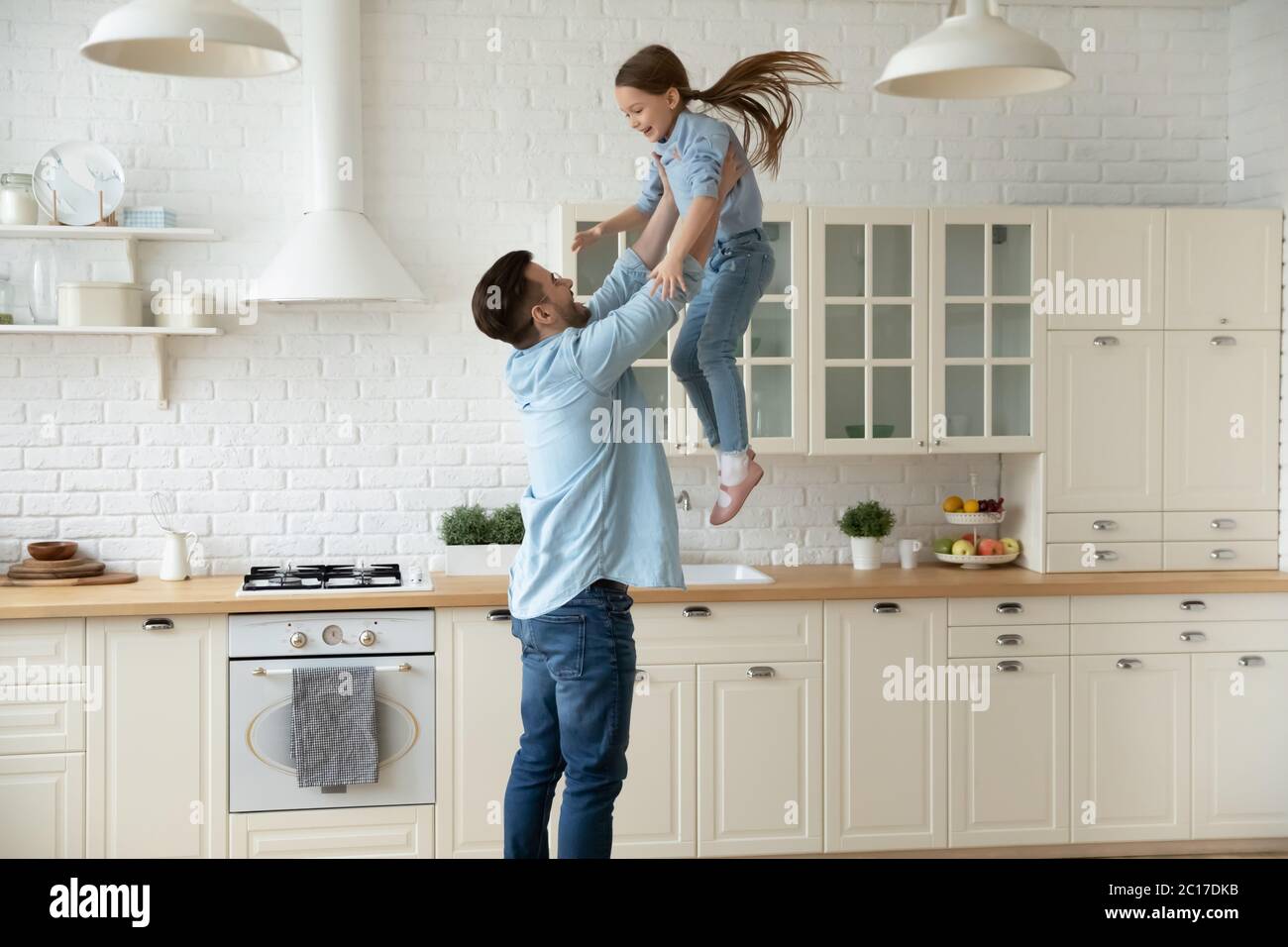 Glücklicher Vater hebt sich wirft in der Luft kleine Tochter Stockfoto