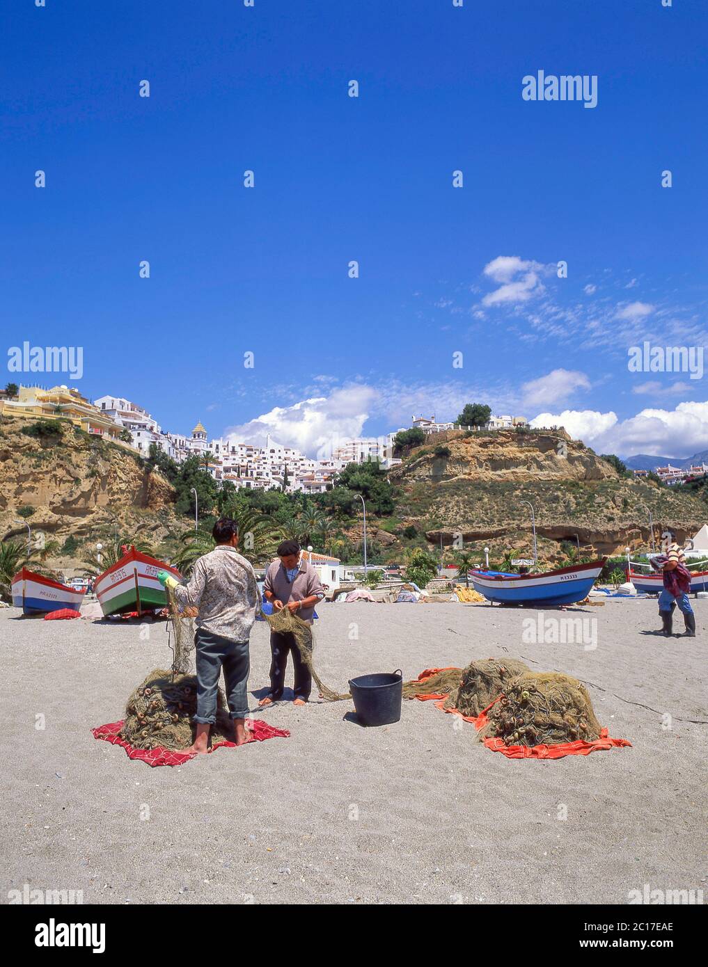Fischer, die Fischernetze am Strand kontrollieren, Nerja, Costa del Sol, Provinz Malaga, Andalusien, Spanien Stockfoto