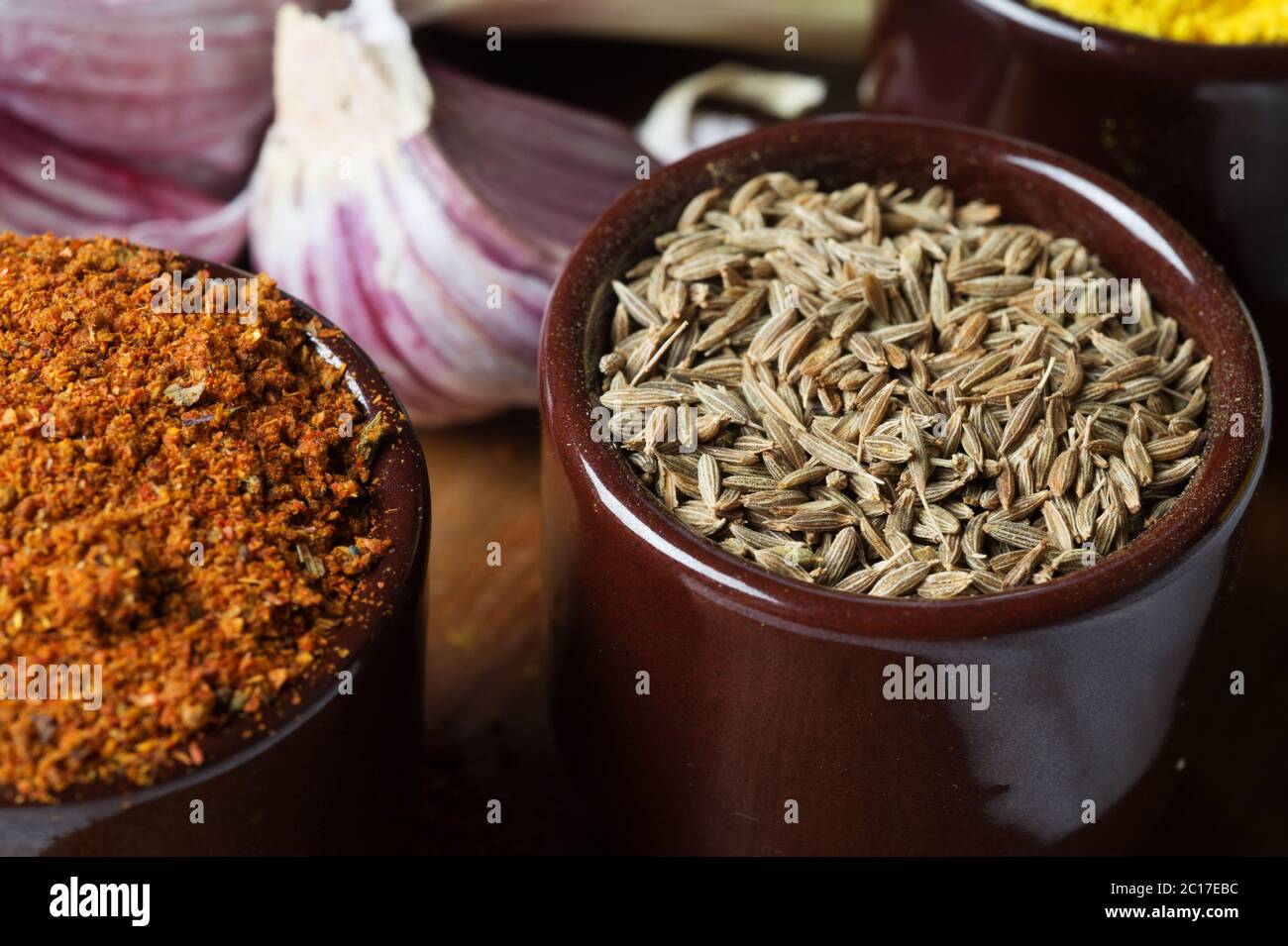 Gewürze und Kräuter in Keramikschalen. Zira Würze. Bunte natürliche Zusatzstoffe. Stockfoto