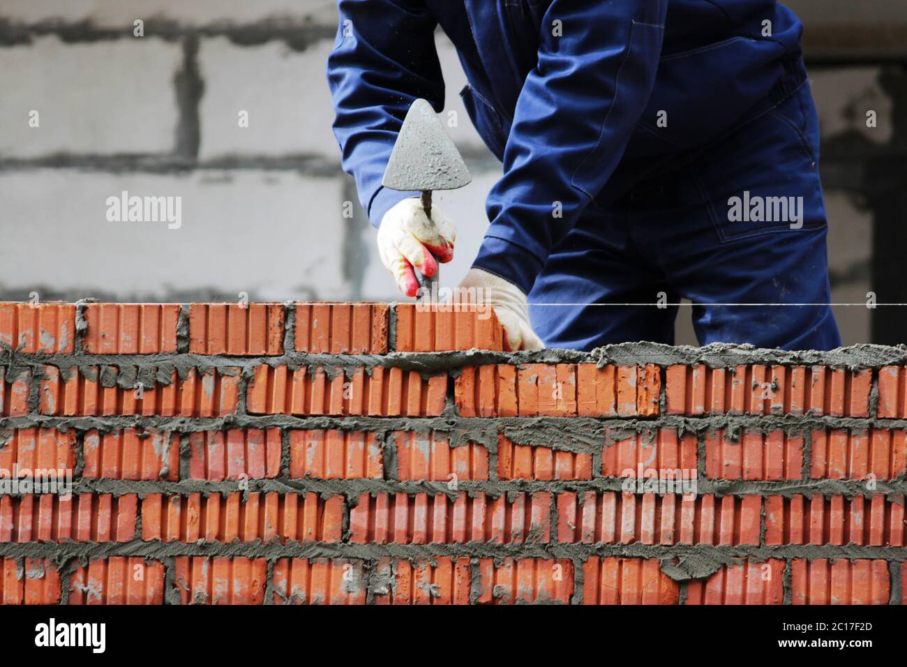 Professionelle Bauarbeiter legen Ziegelsteine und Hausbau auf Industriegelände. Stockfoto