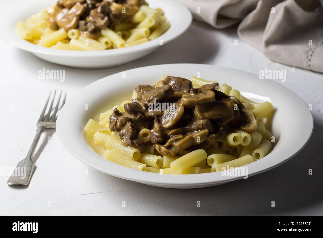 Abendmahl Platten mit dicken, cremigen Pilz und Stroganoff auf Pasta und rustikalen weißer Hintergrund Stockfoto