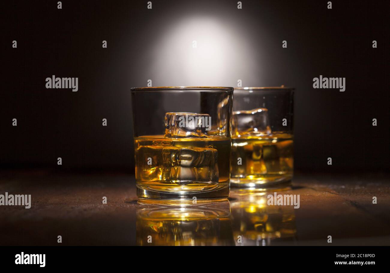 Zwei Gläser Whiskey mit Eiswürfeln auf Holzbrettern. Stockfoto