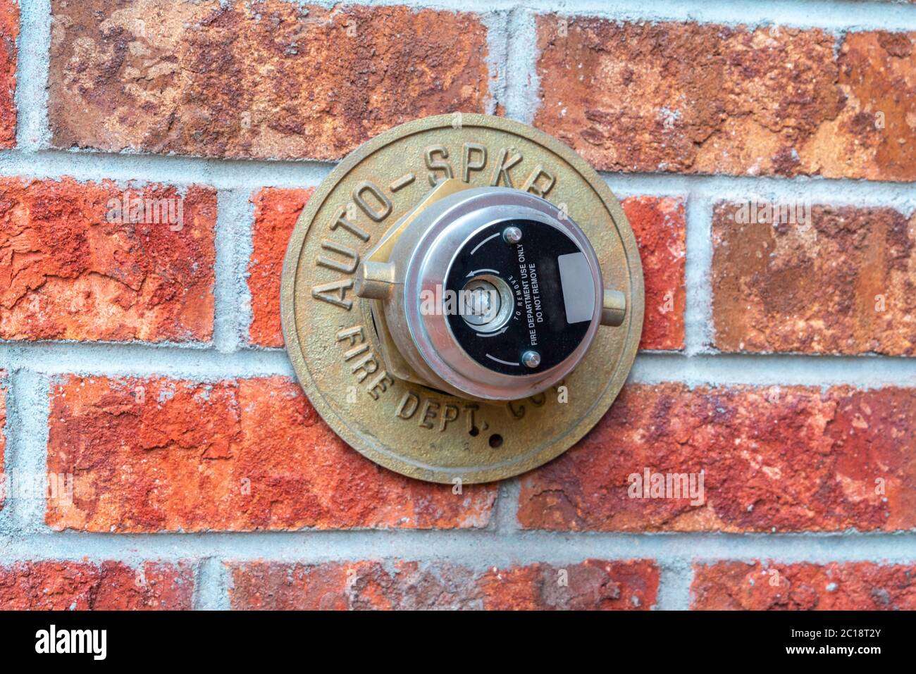 Automatischer Sprinkler an einer Ziegelwand Stockfoto