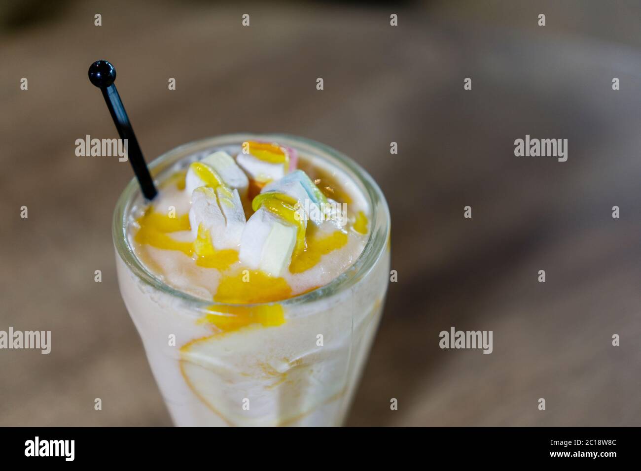 Mango Lassi oder Joghurt, indische beliebte Sommergetränk serviert in Glas, gekrönt mit Marshmallow. Stockfoto