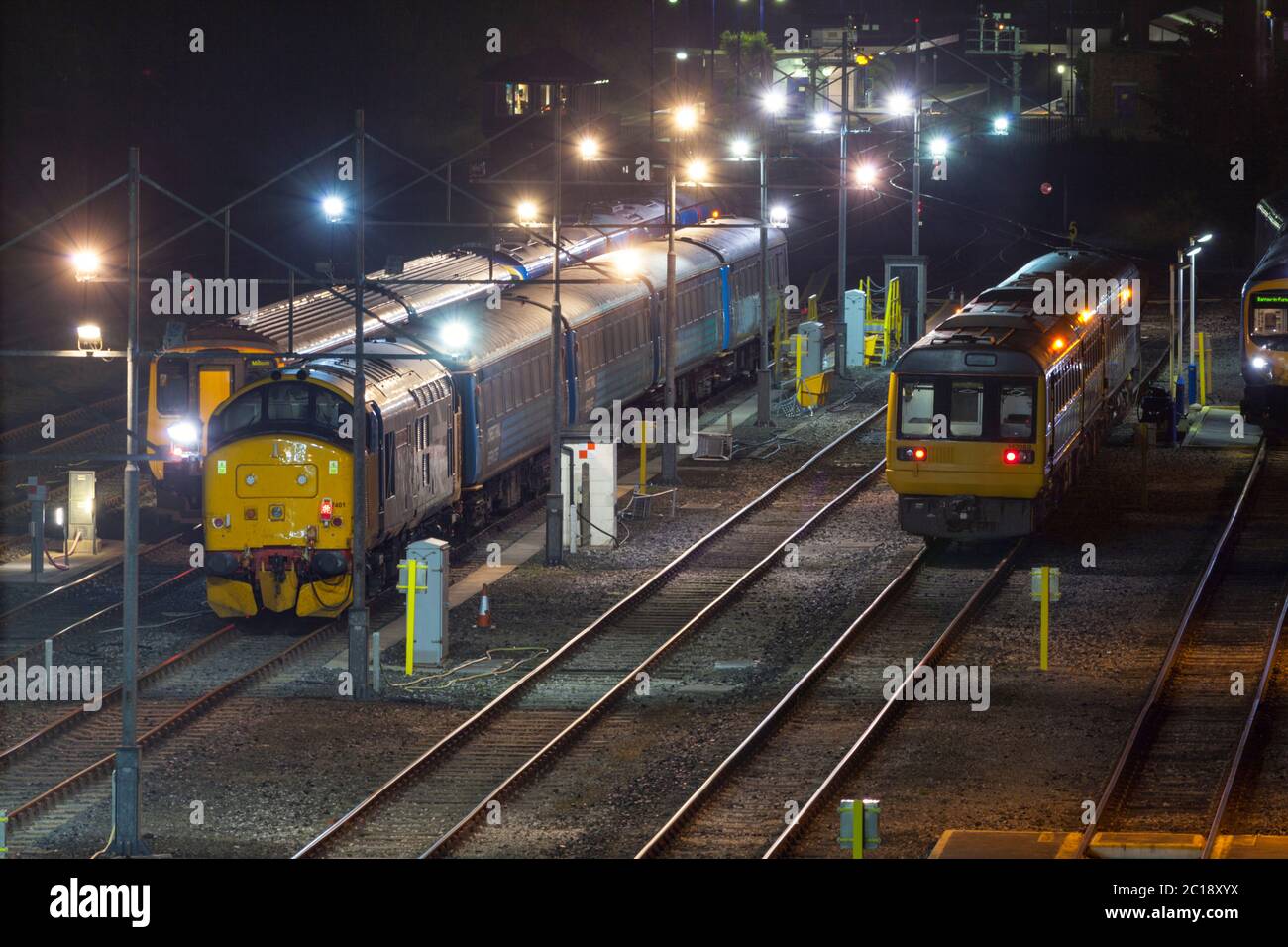 Die Nordbahn der Baureihe 142 Pacer 142089 und die DRS der Baureihe 37 Lokomotive 37401 sind bei Barrow in Furness an den Wagenabfahrten abgestellt Stockfoto