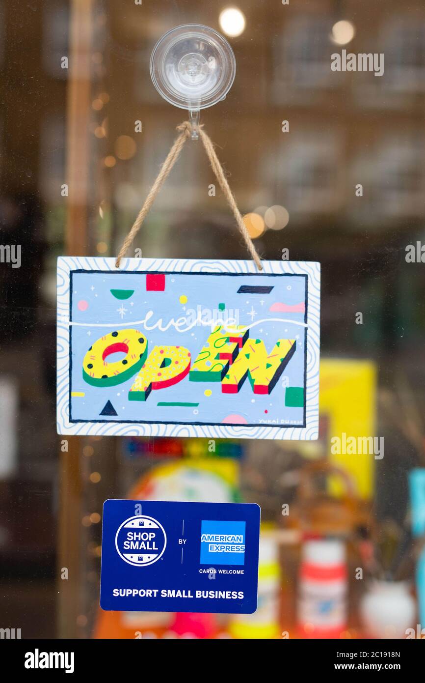 Ein Schild mit der Aufschrift „WE’RE OPEN“, das vom Künstler Yukai Du entworfen wurde, wurde geschaffen, um die Small-Kampagne des American Express Shops zu feiern und Menschen in unseren Straßen in London willkommen zu heißen. Stockfoto