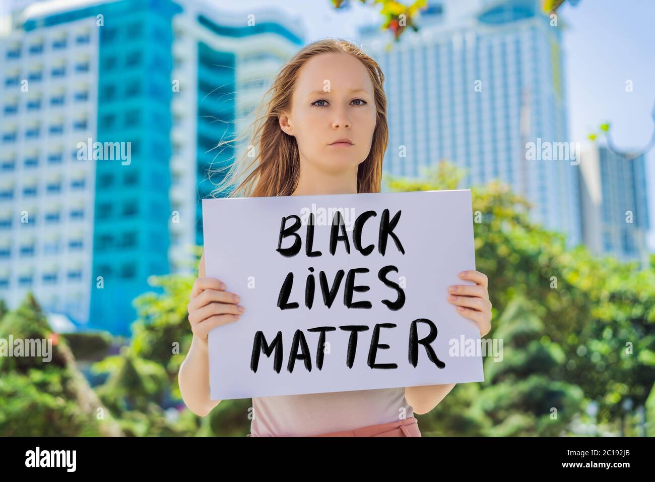 Frau hält ein Plakat mit einer Inschrift - schwarz lebt Materie Stockfoto