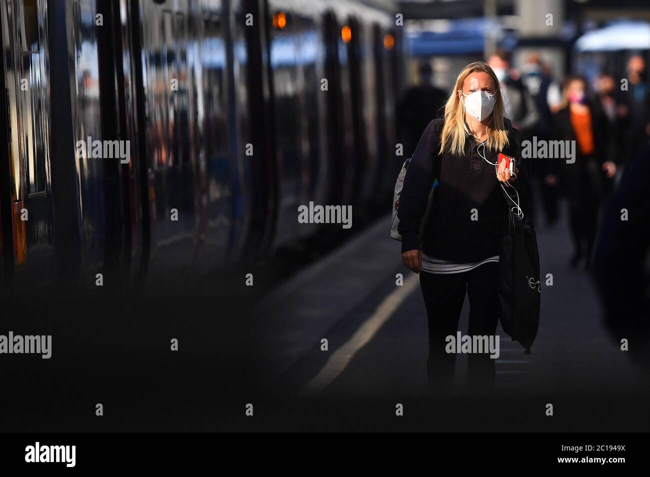 Ein Passagier mit Gesichtsmaske am Bahnhof Waterloo in London, da Gesichtsbedeckungen für den öffentlichen Verkehr in England obligatorisch werden, da während der Coronavirus-Pandemie weitere Sperrbeschränkungen aufgehoben werden. Stockfoto
