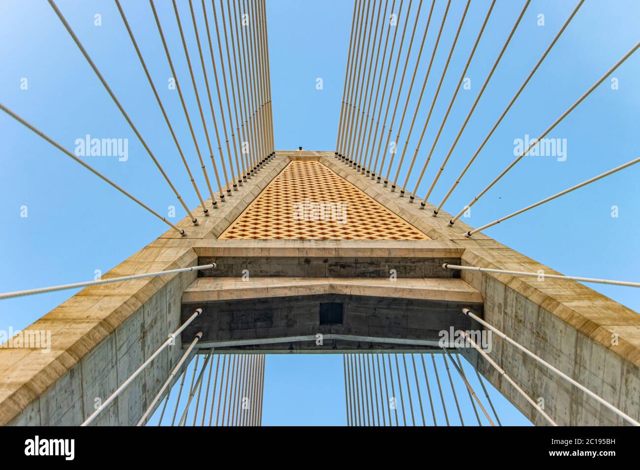 Betonbrücken-Pylon mit parallelen Leitungen aus Stahlseil. Durchgang unter dem Stützturm der Kabelbrücke. Konstruktion Kabelgestabebrücke aga Stockfoto