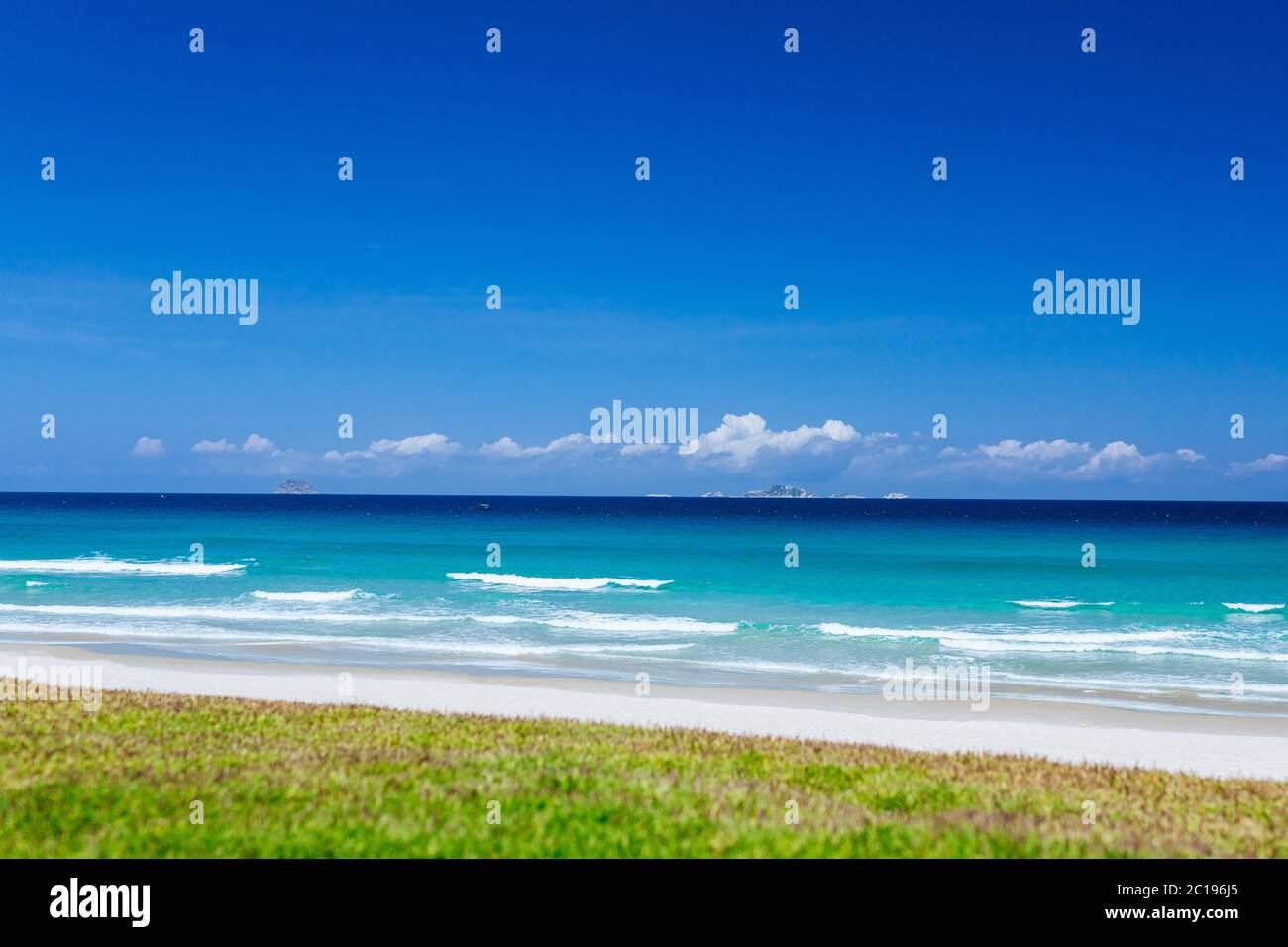 Exotischer Strand für eine schöne Kulisse oder Bildschirmschoner, mit azurblauem Wasser im Meer und klaren blauen Himmel mit weißen Wolken. Konzept der Reise, Sommer vaca Stockfoto