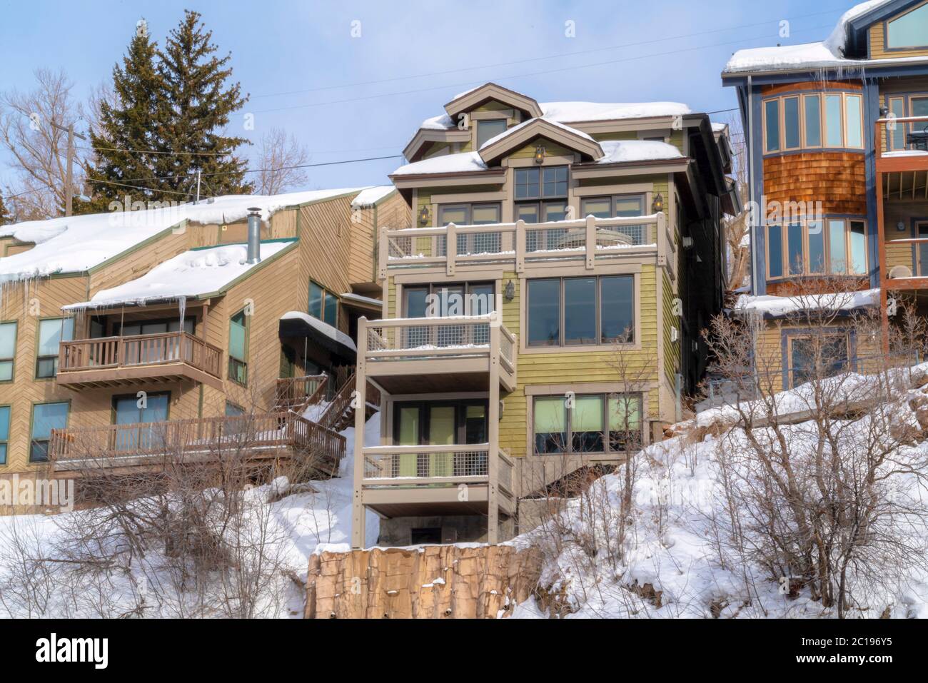 Schnee und Eiszapfen auf den Dächern von Berghäusern in Park City Utah im Winter Stockfoto