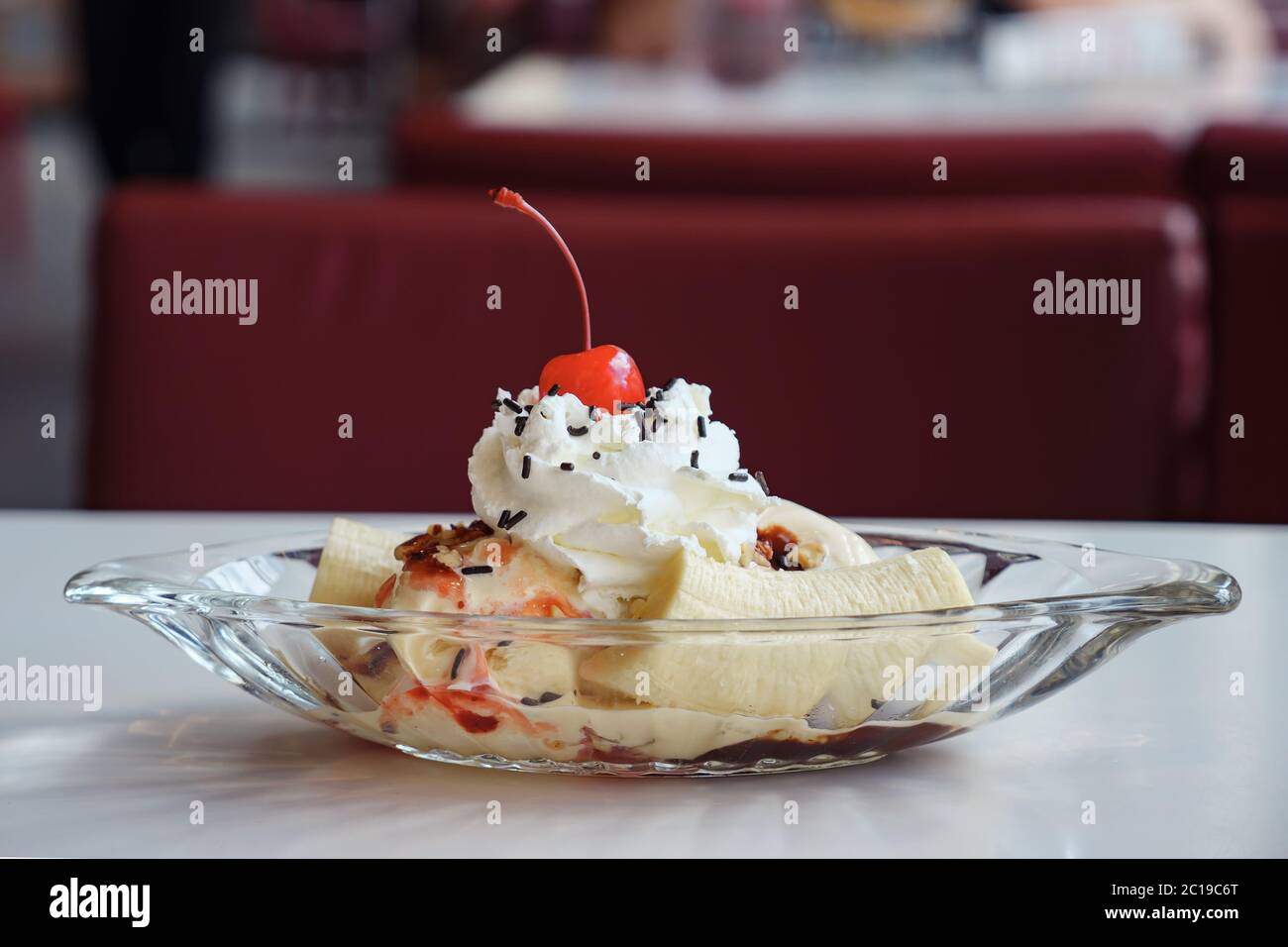 Eis in einer Bootsplatte mit Banane und Kirsche verziert. Stockfoto