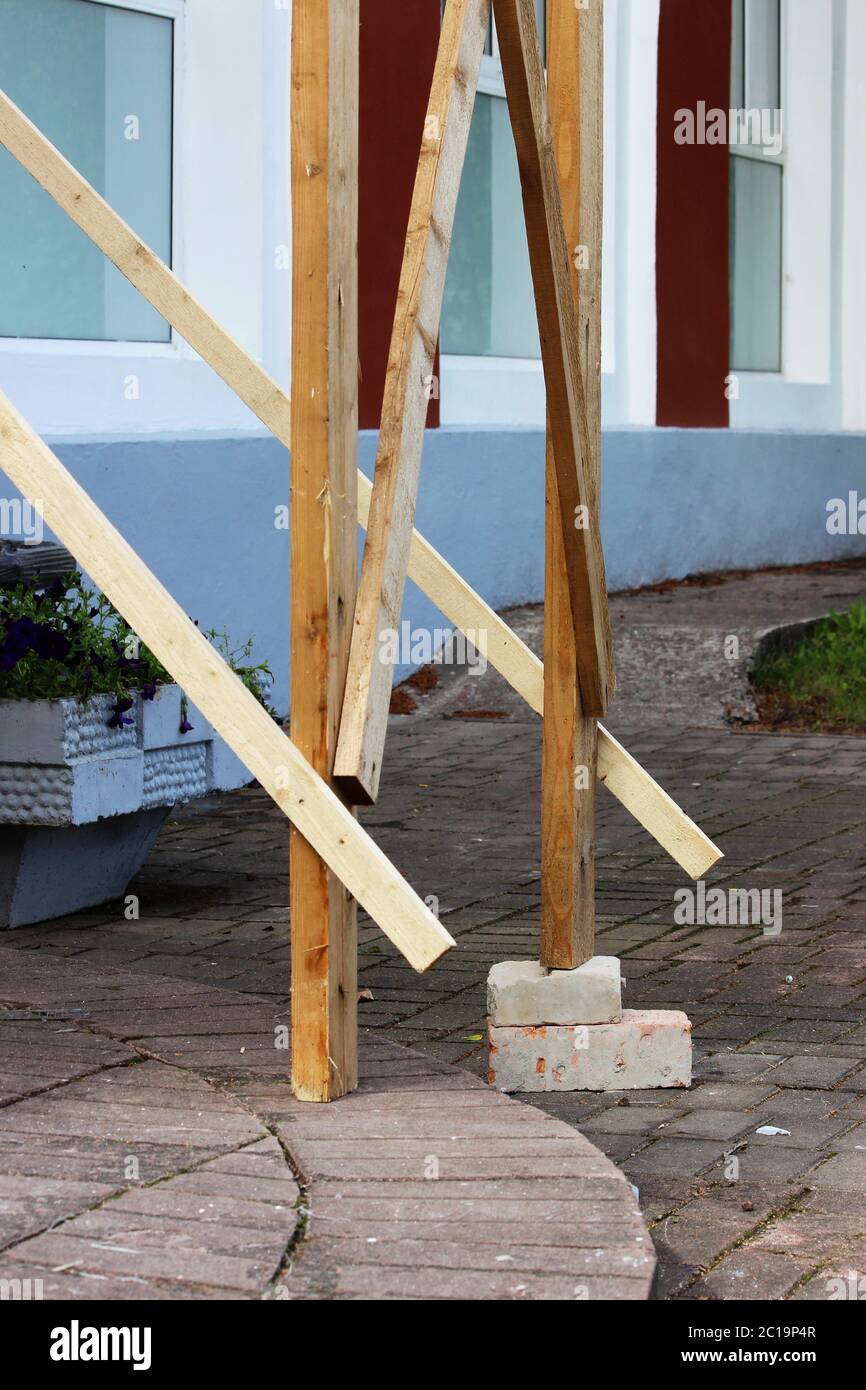 Holz- Gerüst mit Backsteinen, unter dem Fuß für die Arbeitnehmer Gipser. Reportage. Sicherheit Verletzung. Stockfoto