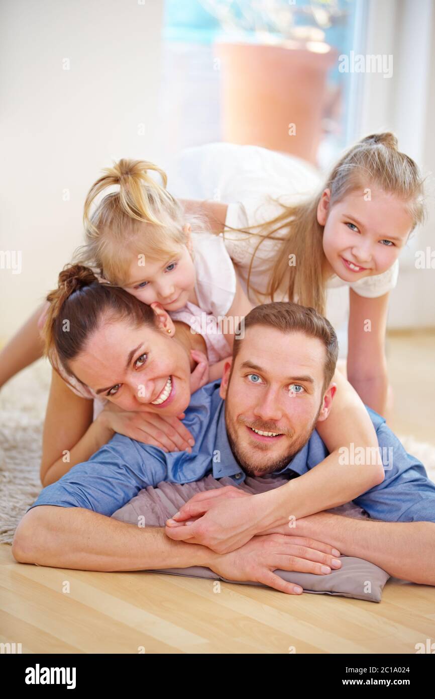 Glückliche Familie mit zwei Töchtern im Wohnzimmer aus dem Haus Stockfoto