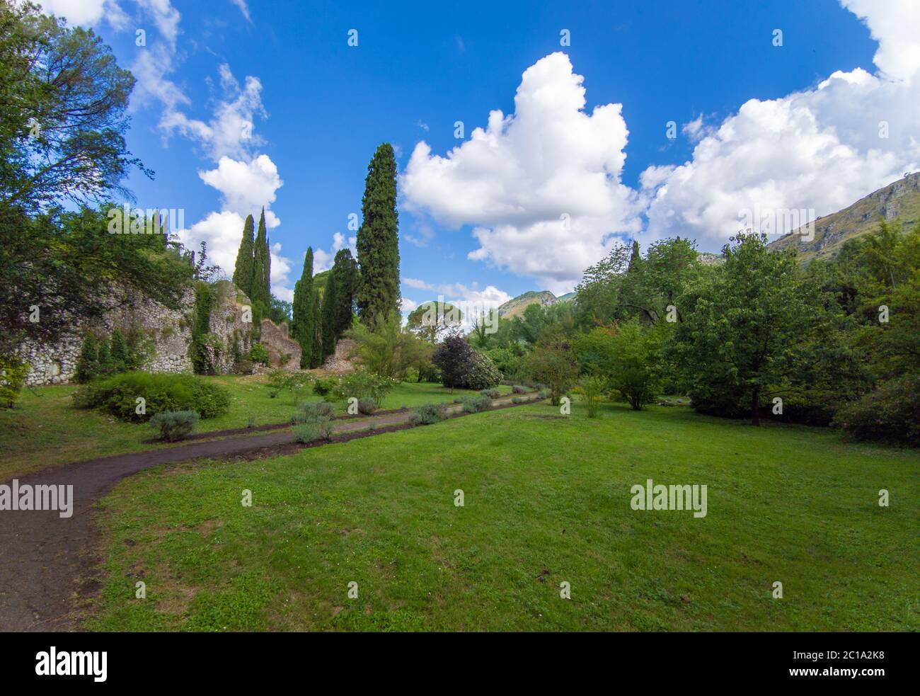Garten von Ninfa (Latina, Italien) - EIN privates Naturdenkmal mit mittelalterlichen Ruinen in Stein, Blumen Park und ein ehrfürchtiges Wildbach mit wenig Fall. Stockfoto