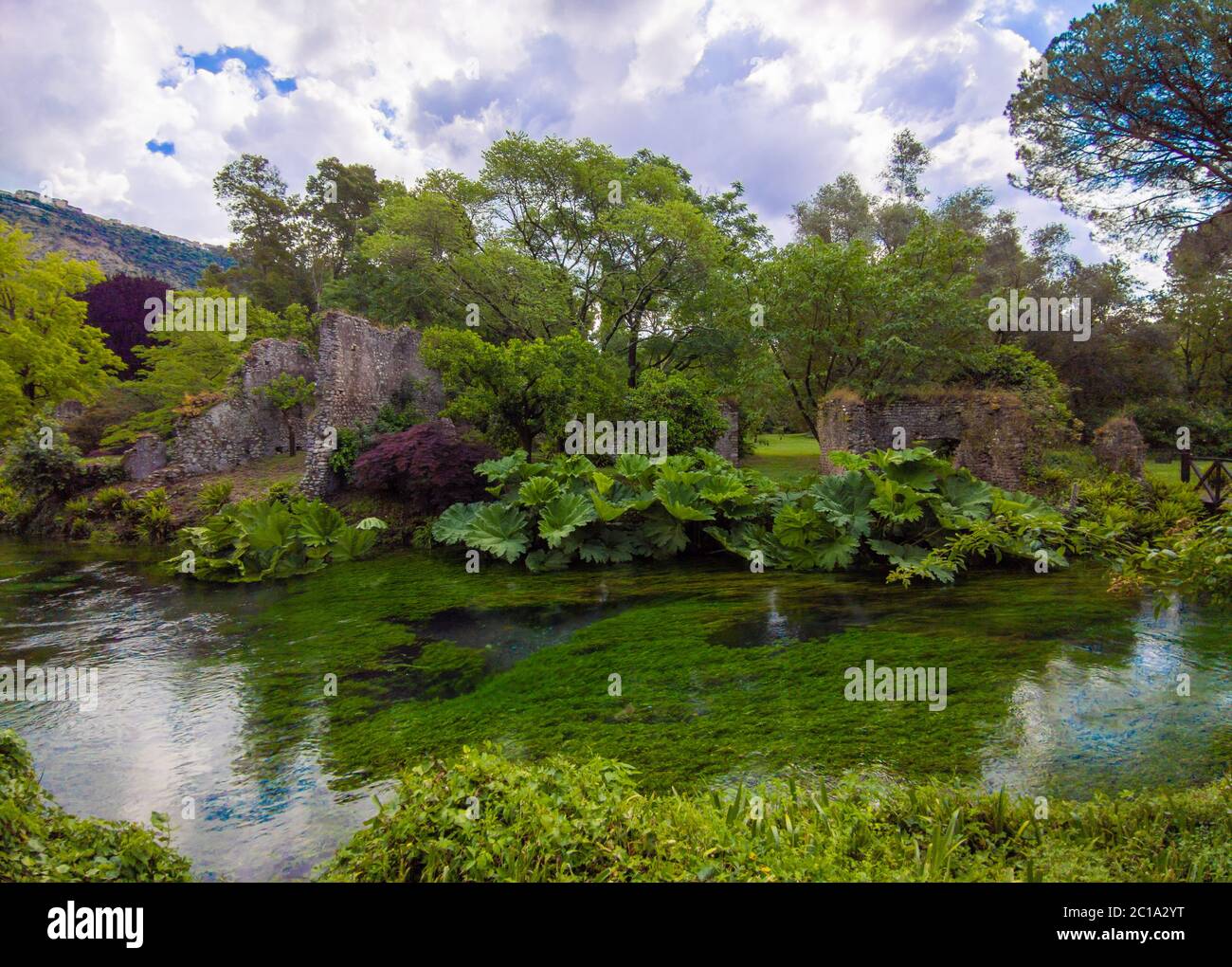 Garten von Ninfa (Latina, Italien) - EIN privates Naturdenkmal mit mittelalterlichen Ruinen in Stein, Blumen Park und ein ehrfürchtiges Wildbach mit wenig Fall. Stockfoto