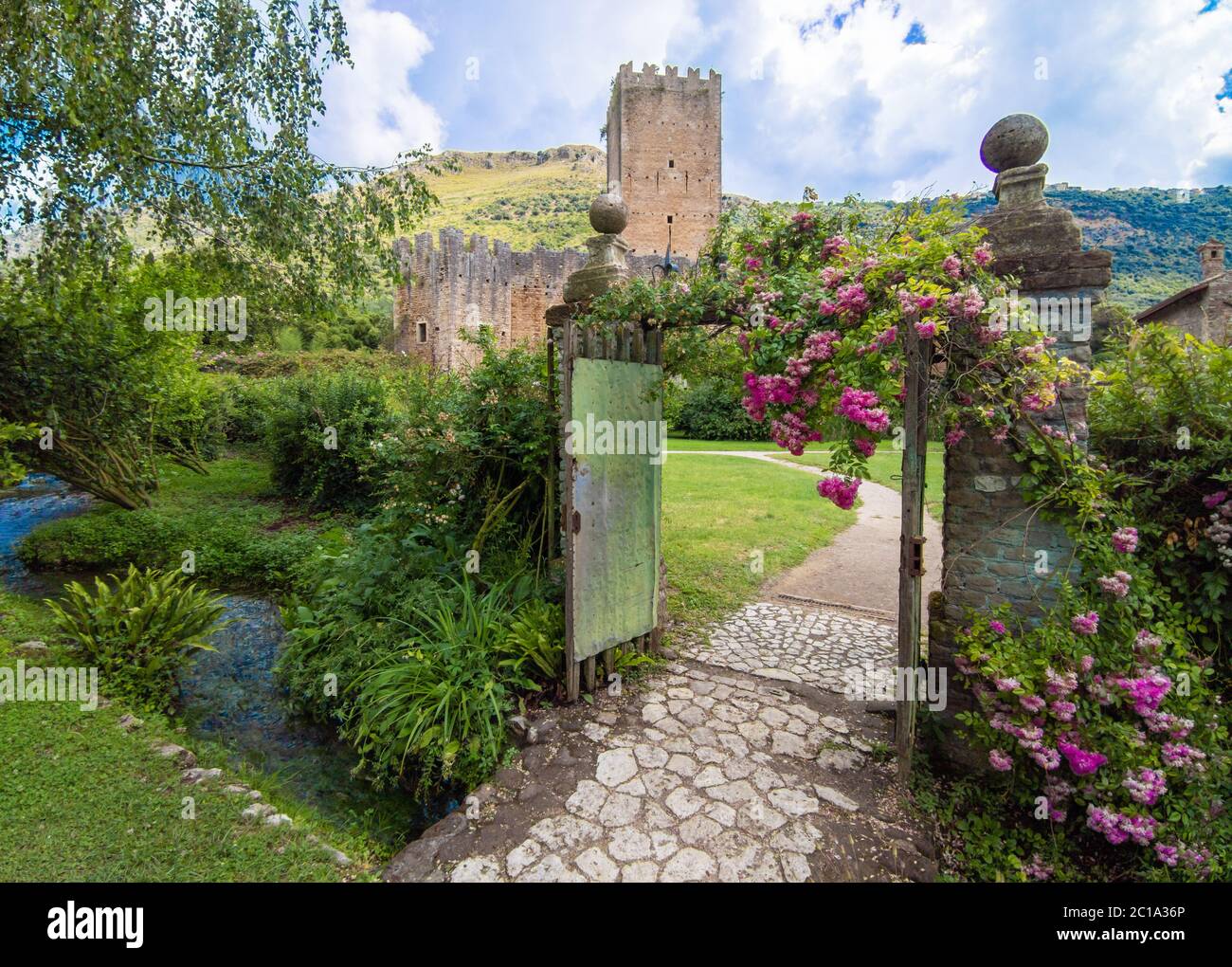 Garten von Ninfa (Latina, Italien) - EIN privates Naturdenkmal mit mittelalterlichen Ruinen in Stein, Blumen Park und ein ehrfürchtiges Wildbach mit wenig Fall. Stockfoto