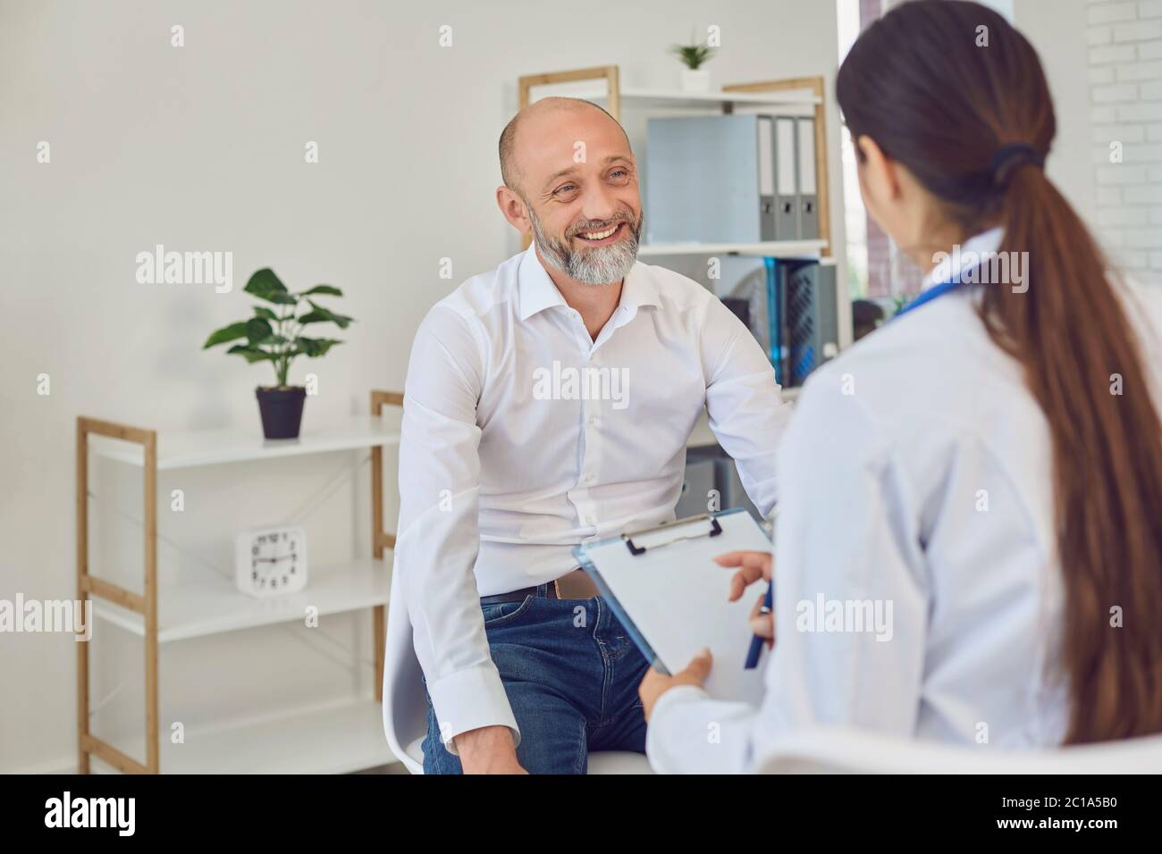 Ein Mann mittleren Alters spricht mit einem Arzt im Büro. Ärztliche Beratung Diagnose Rezept in einem Krankenhaus Stockfoto