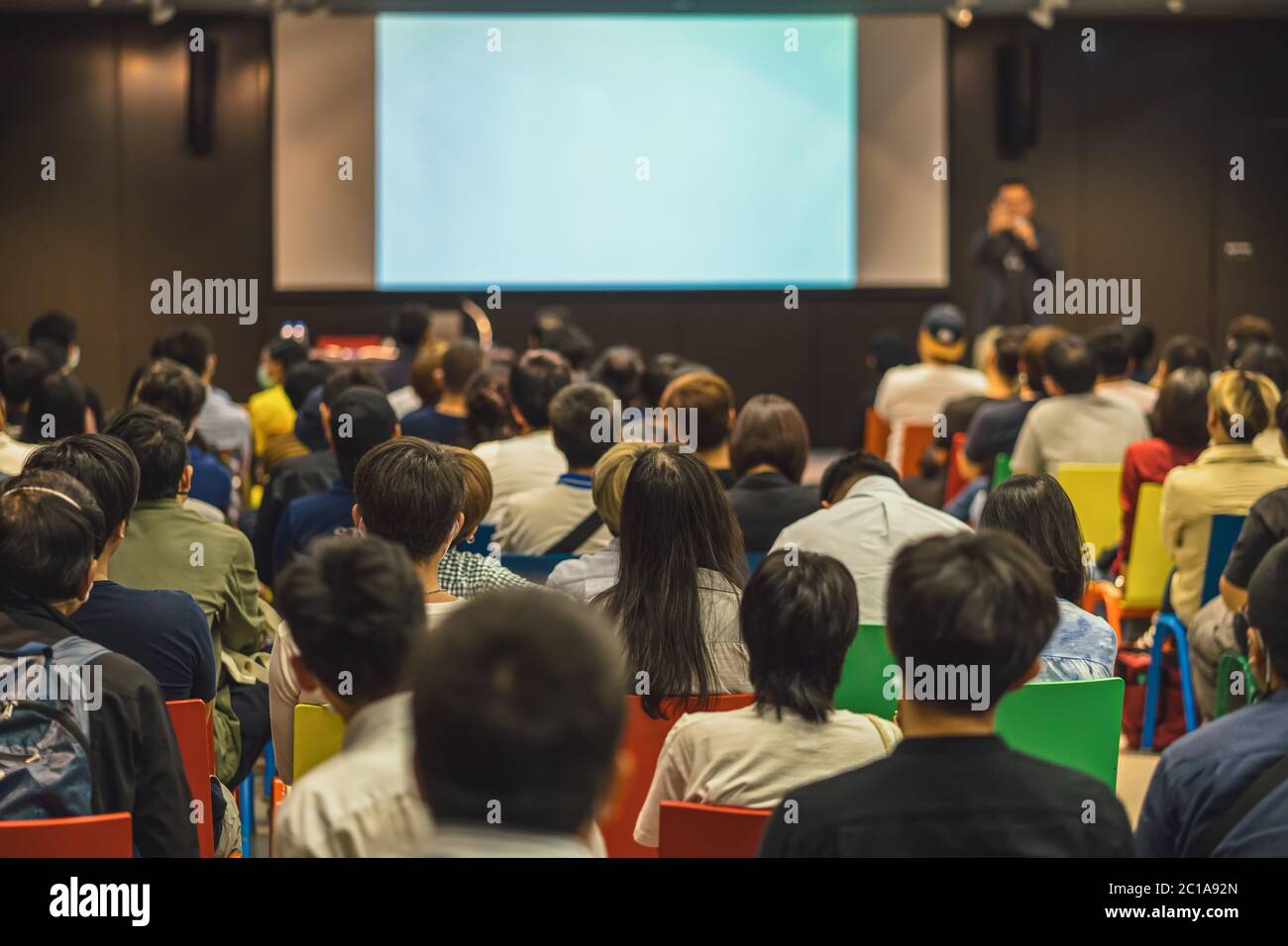 Rückansicht des asiatischen Publikums, der mit dem Sprecher auf der Bühne im Seminarkonferenzraum oder im Konferenzsaal, in der Ausbildung und im Workshop spricht, Stockfoto