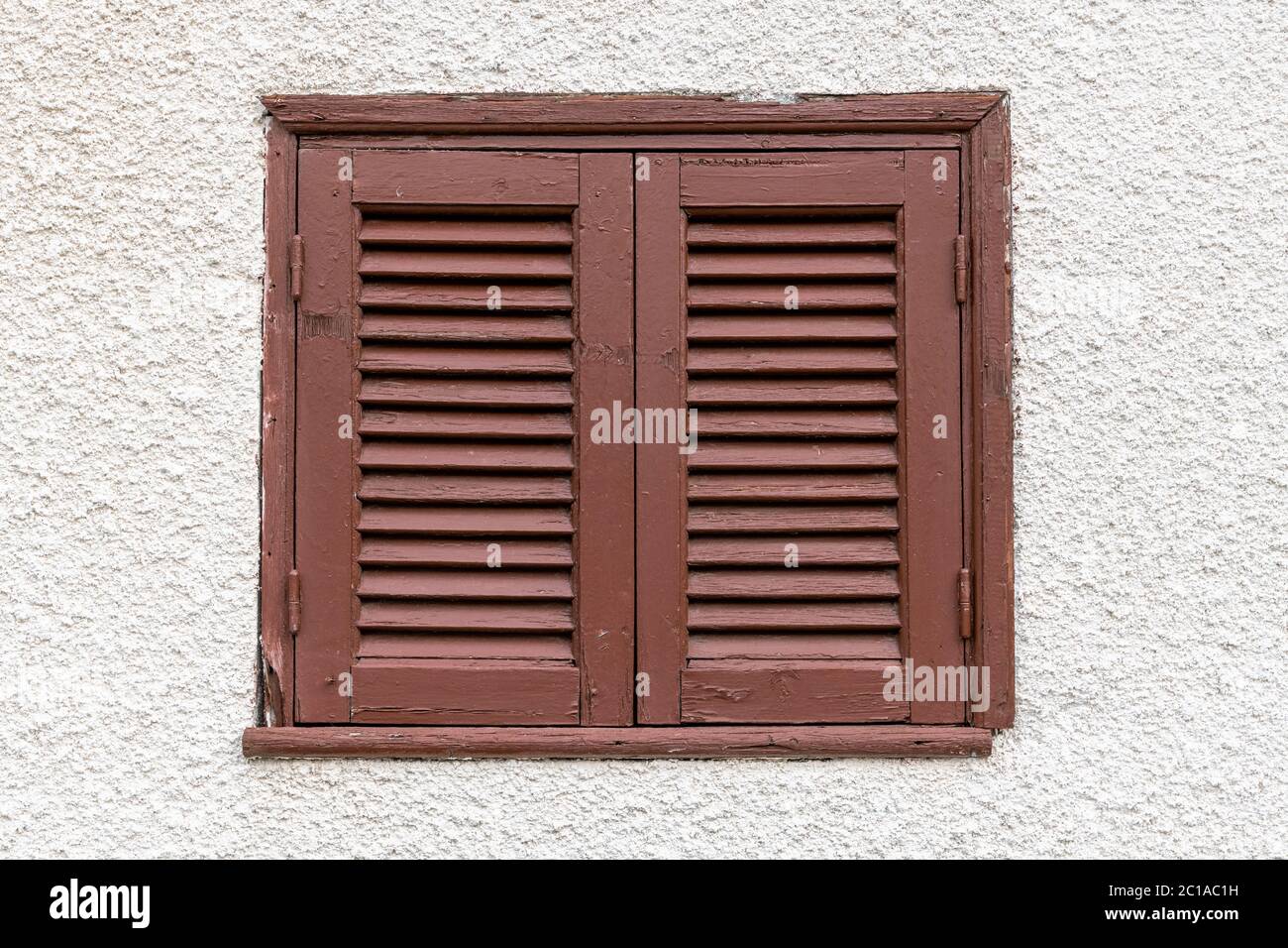 Geschlossenes Fenster mit braunen Fensterläden an einer hellen Wand, Zypern Stockfoto