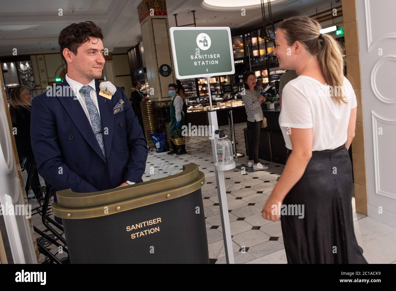 Mitarbeiter Willkommen Kunden zurück in Harrods Geschäft in Knightsbridge, London, wie es seine Türen öffnet, nachdem die Regierung angekündigt, dass nicht-wesentliche Geschäfte wieder öffnen können. Stockfoto