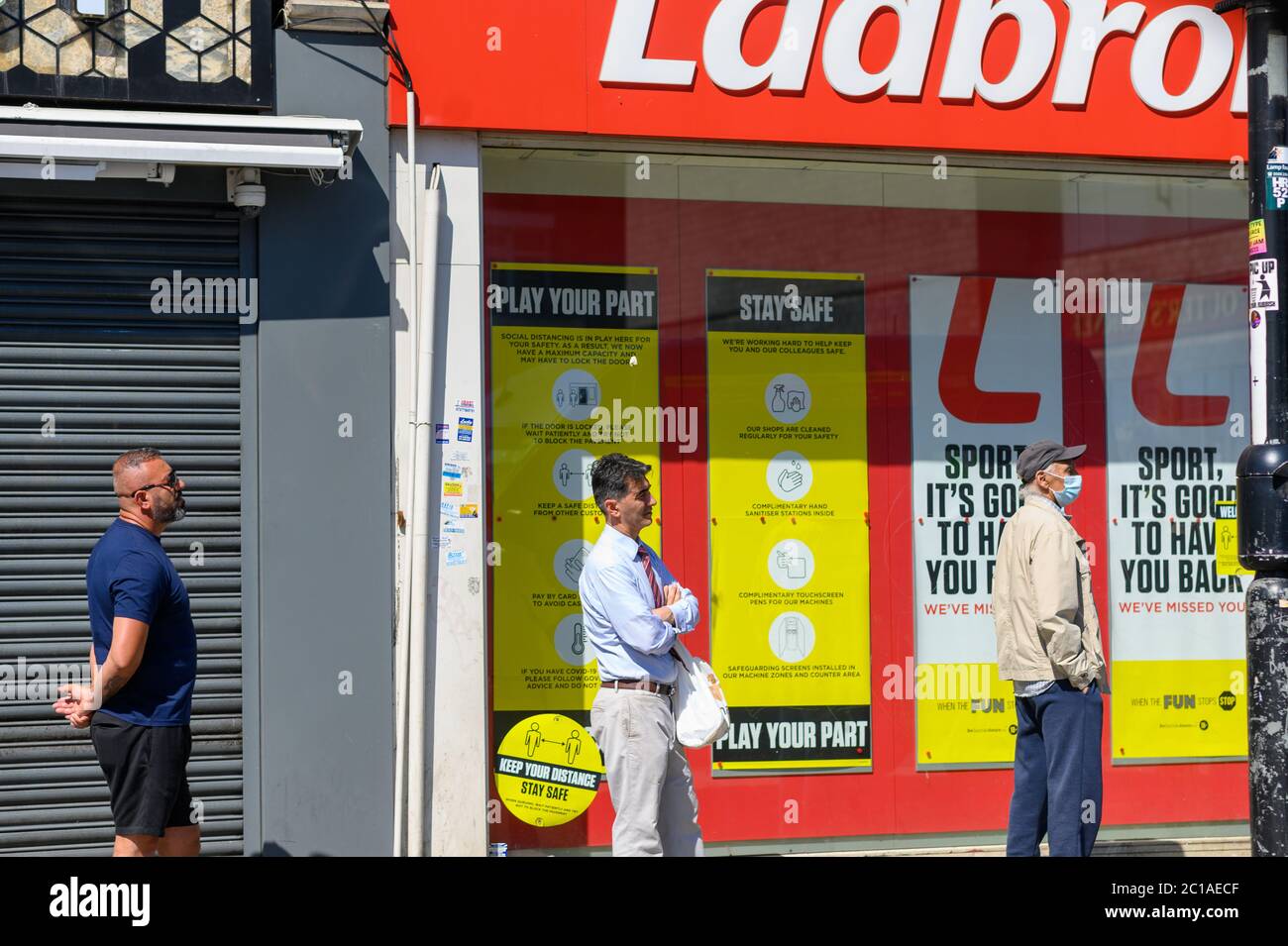 Spieler, die sich außerhalb von Ladbrokes Sports anstellen und darauf warten, eine Wette zu platzieren. Stockfoto