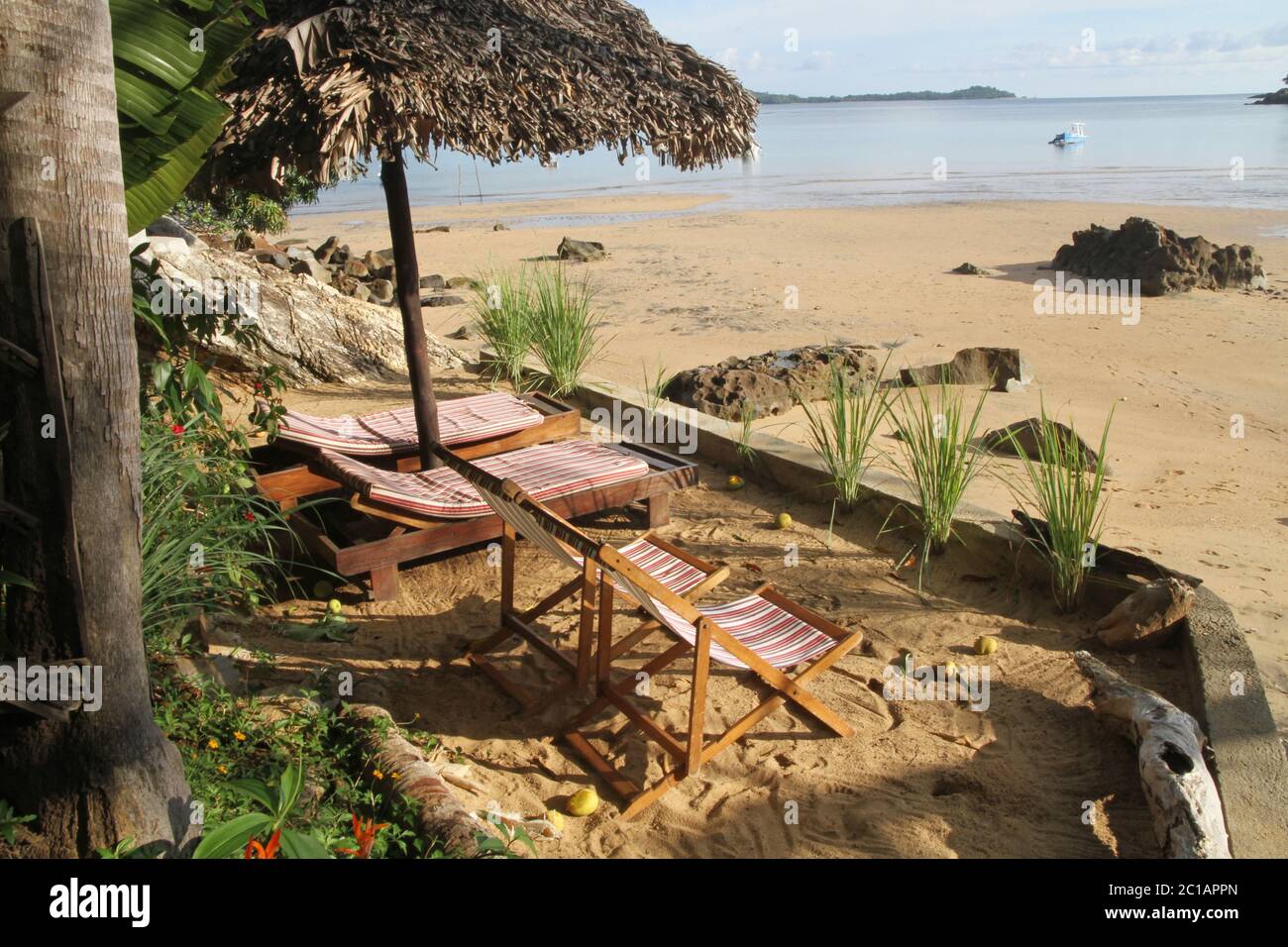 Liegestühle, Stühle, Zitronengras unter Palmleaved Stroh Lapa auf Breach, Ampangorinana Village, Nosy Komba Island, Magadascar. Stockfoto