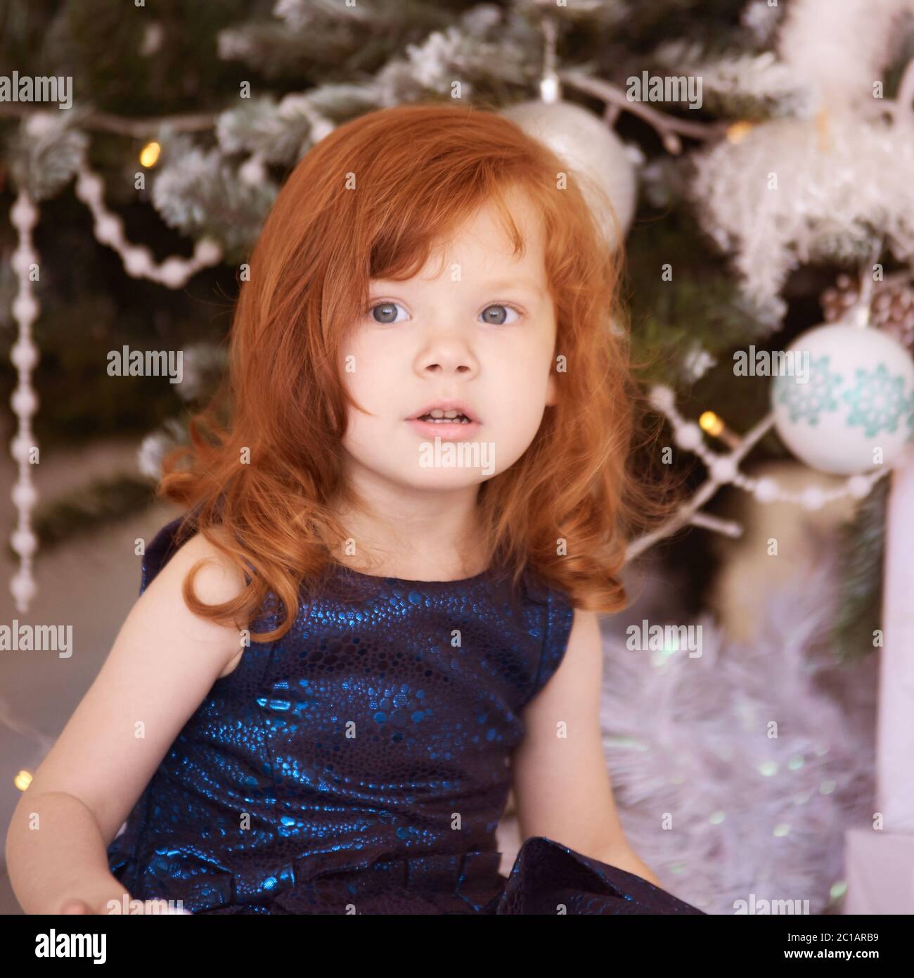 Kleines Mädchen. Neujahr Weihnachten Kind. Weihnachtsfeiertag. Interieur. Interieur. Rote Haare. Horizontal Stockfoto