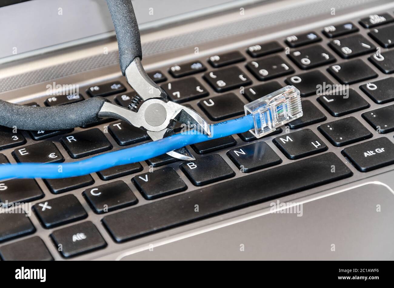 Zange schneidet Internet-Kabel auf Computer-Tastatur Stockfoto