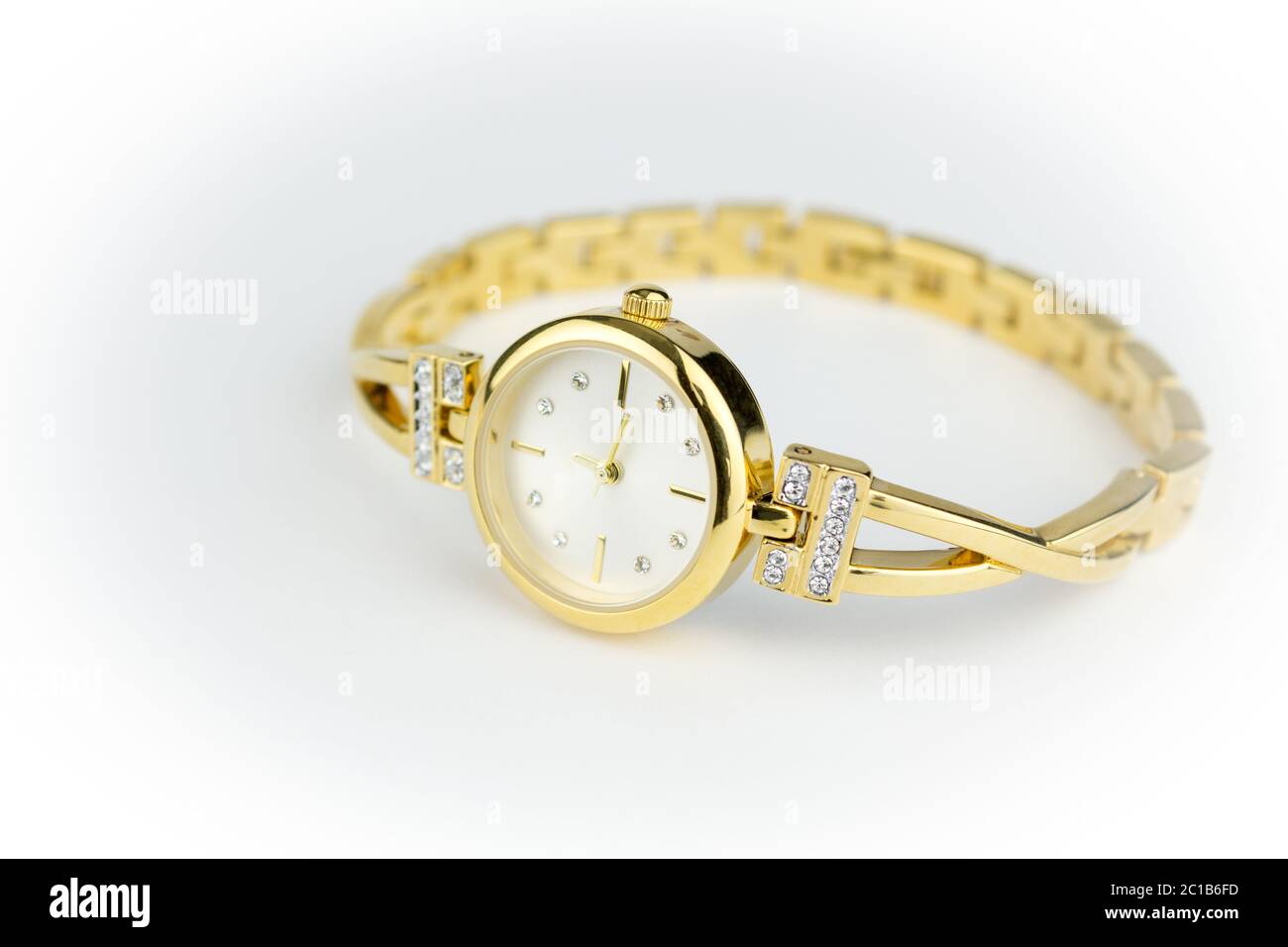 Damen Uhr Gold mit Diamanten auf weißem Hintergrund mit schmalen Tiefenschärfe isoliert Stockfoto