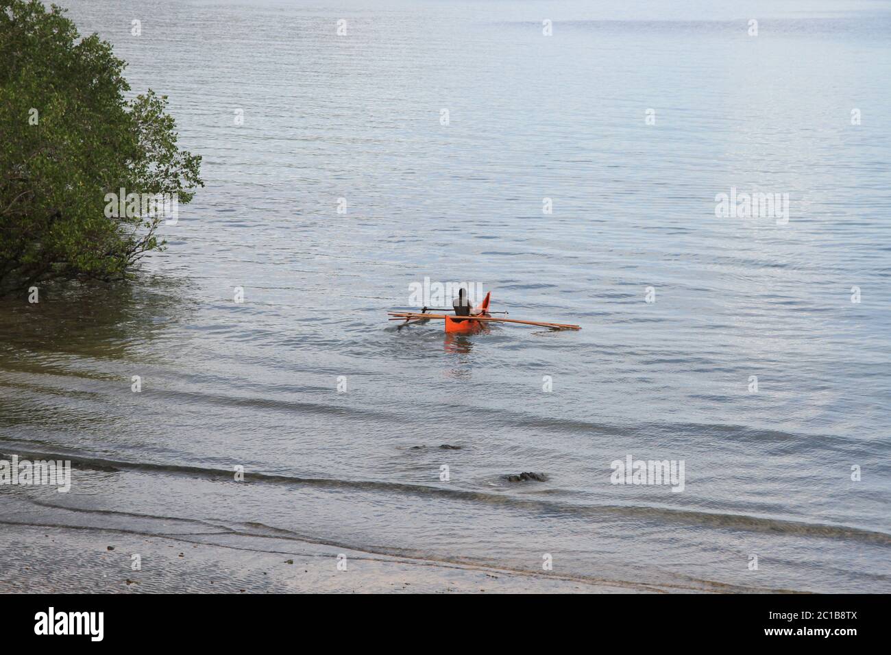 Lokaler Fischer im Kanu am Strand in der Nähe von Mangroven, Ampangorinana Dorf, Nosy Komba Insel, Madagaskar. Stockfoto