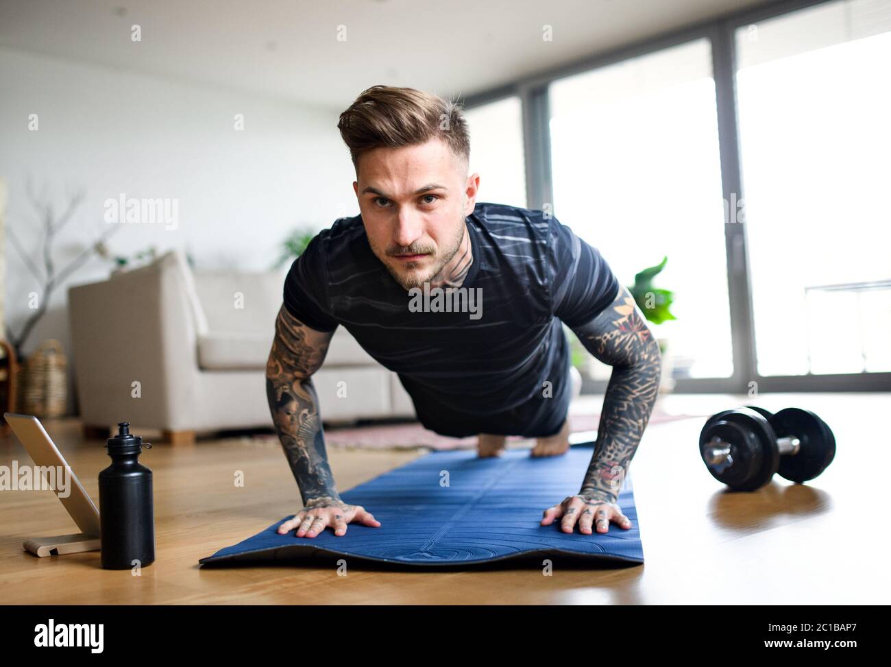 Vorderansicht Porträt des Mannes mit Tablet, der zuhause Workout macht. Stockfoto