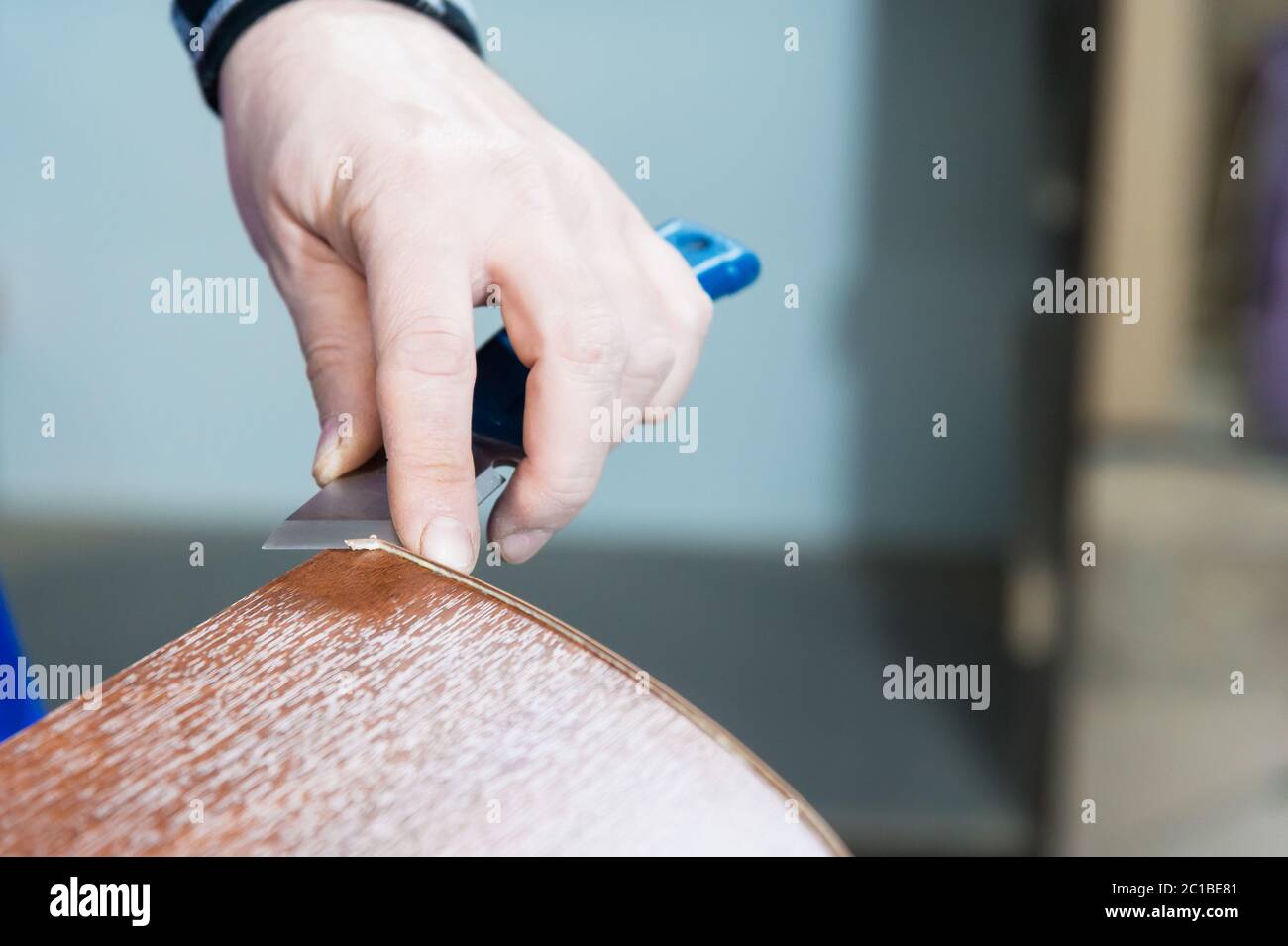 Eine Nahaufnahme der nicht gepflegten Hände des echten männlichen Zimmermanns rundet das Finish der Spanplatten-Details der Möbel ab Stockfoto