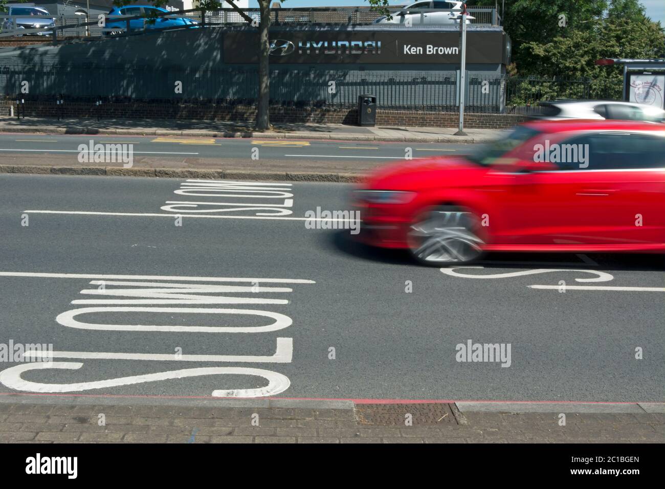 Straßenmarkierungen Warnung Verkehr zu langsam, auf der Annäherung an Manor Zirkus Kreisverkehr, East Sheen, Südwesten london, england, mit Auto in unscharfer Bewegung Stockfoto