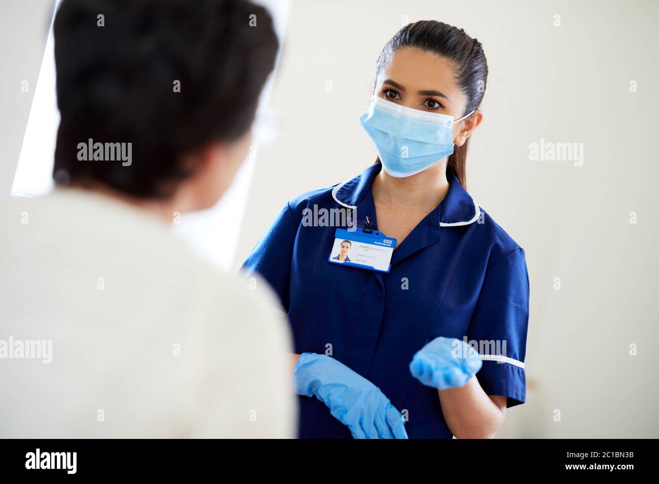 Krankenschwester, die mit dem Patienten spricht und die PSA trägt Stockfoto