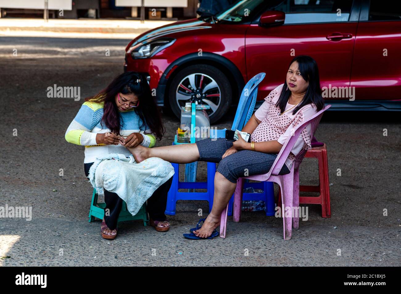 Eine Frau hat EINE Pediküre in der Straße, Yangon, Myanmar. Stockfoto
