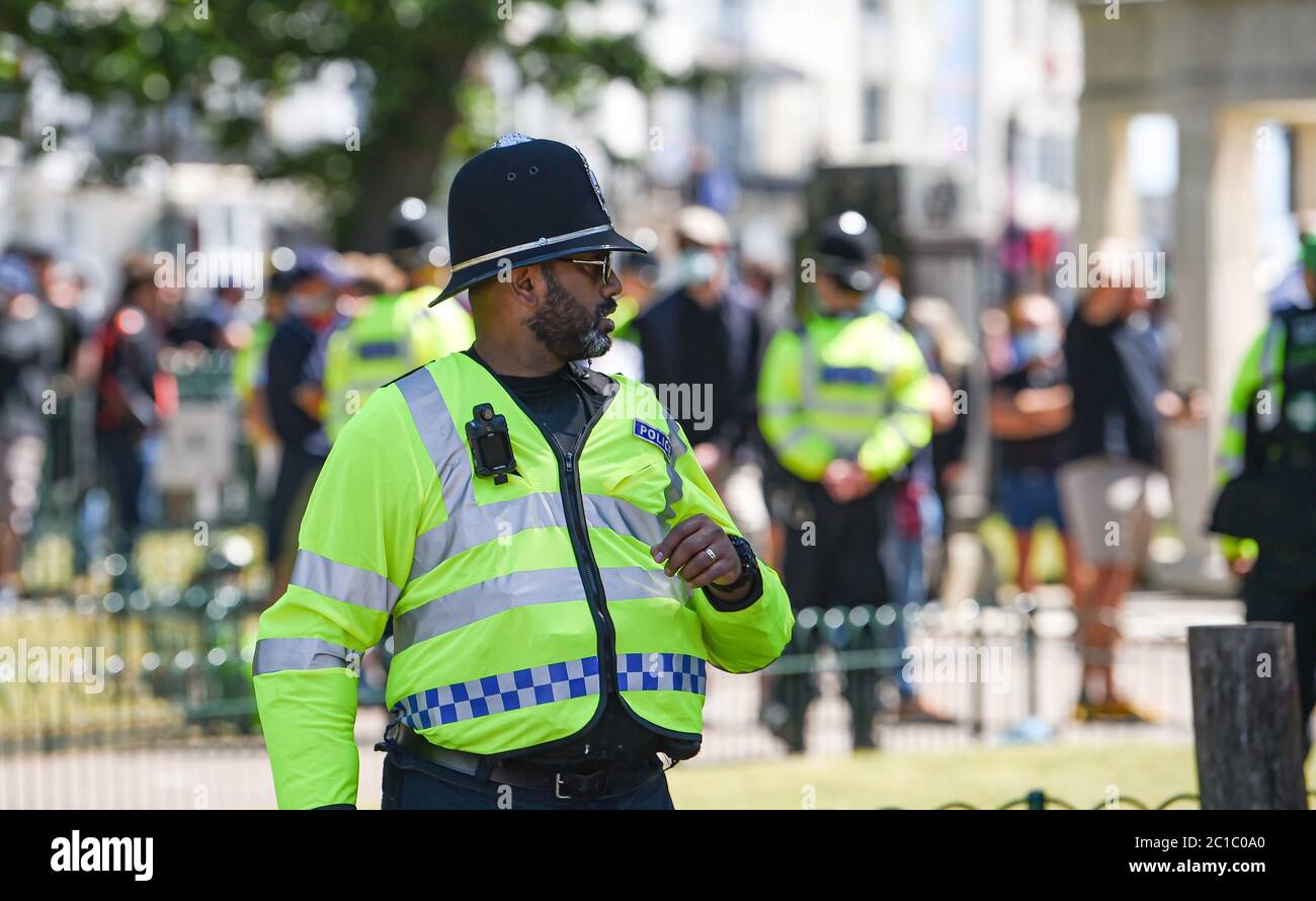 Brighton UK 13. Juni 2020 - EIN schwarzer Polizist mit Sonnenbrille im Dienst am Brighton war Memorial, als Tausende an der Black Lives Matter Anti-Rassismus-Protestkundgebung durch Brighton heute teilnehmen. Es gab Proteste in ganz Amerika, Großbritannien und anderen Ländern seit dem Tod von George Floyd, während er von der Polizei in Minneapolis am 25. Mai verhaftet : Credit Simon Dack / Alamy Live News Stockfoto