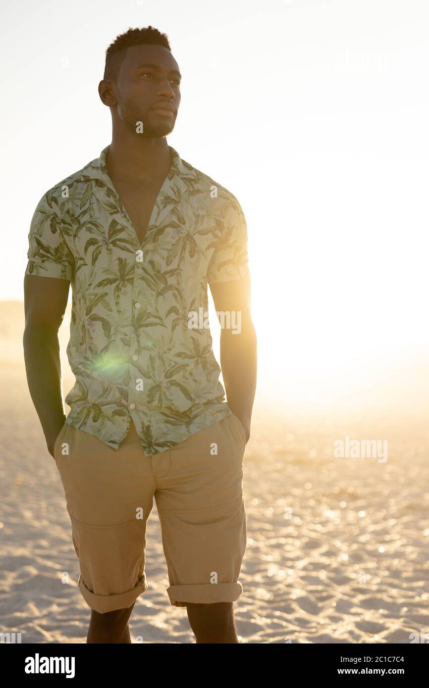 Ein afroamerikanischer Mann, der an einem sonnigen Tag Freizeit am Strand genießt Stockfoto
