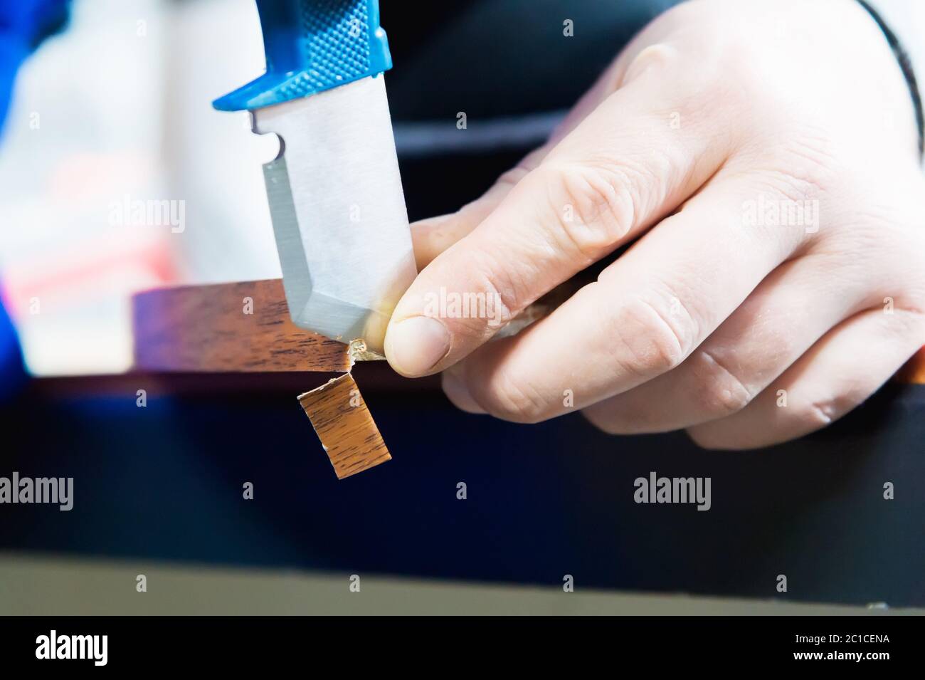 Eine Nahaufnahme der nicht gepflegten Hände des echten männlichen Zimmermanns rundet das Finish der Spanplatten-Details der Möbel ab Stockfoto