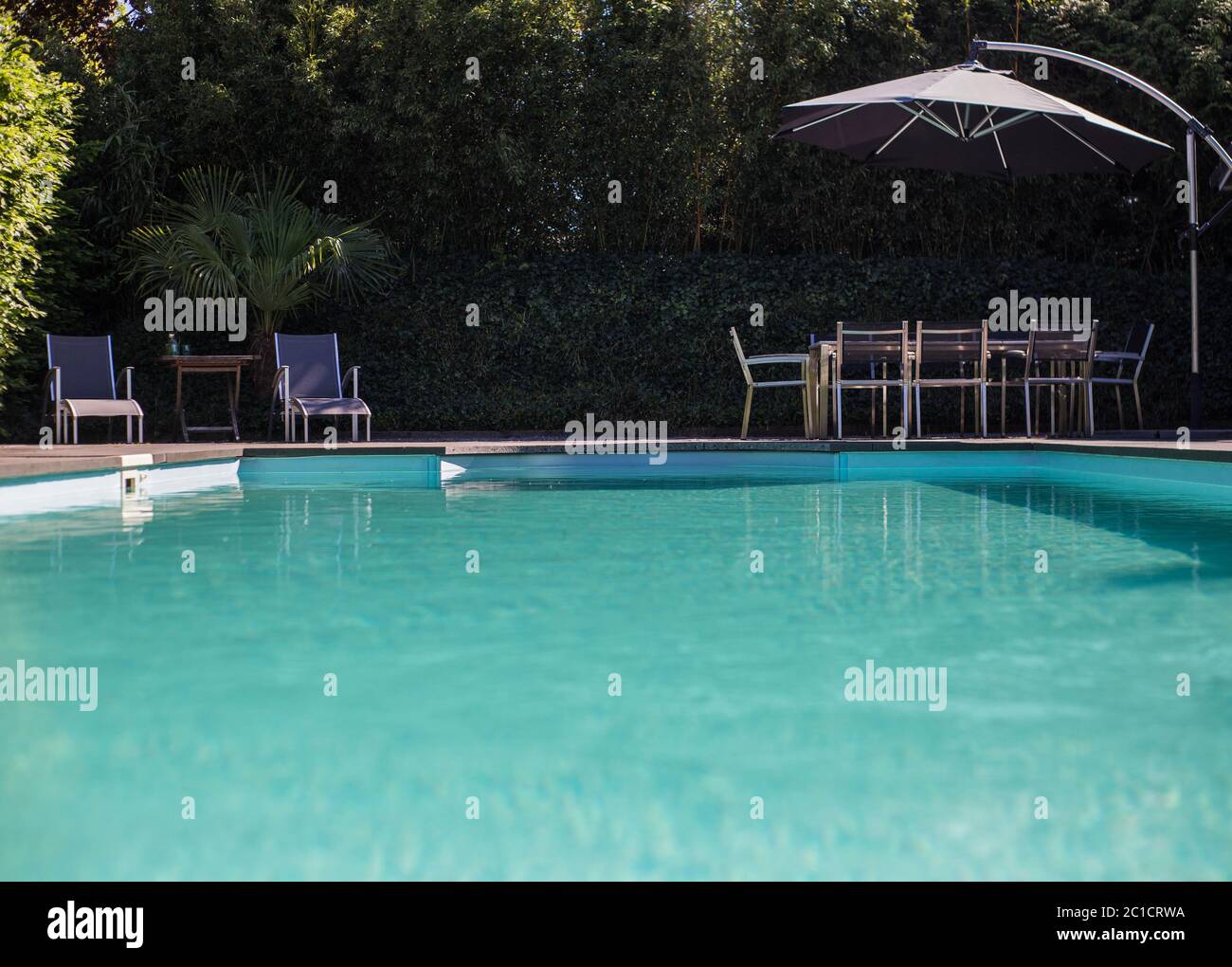 Blau luxus Swimmingpool einer modernen Villa mit einer Couch an einem heißen Sommertag Stockfoto