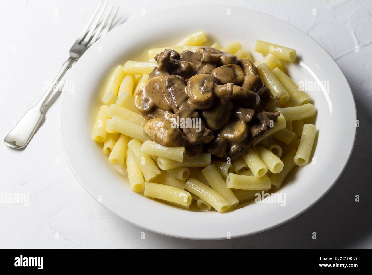 Pilz- und Rindfleisch Stroganoff pasta-Teller auf weißem Hintergrund Stockfoto