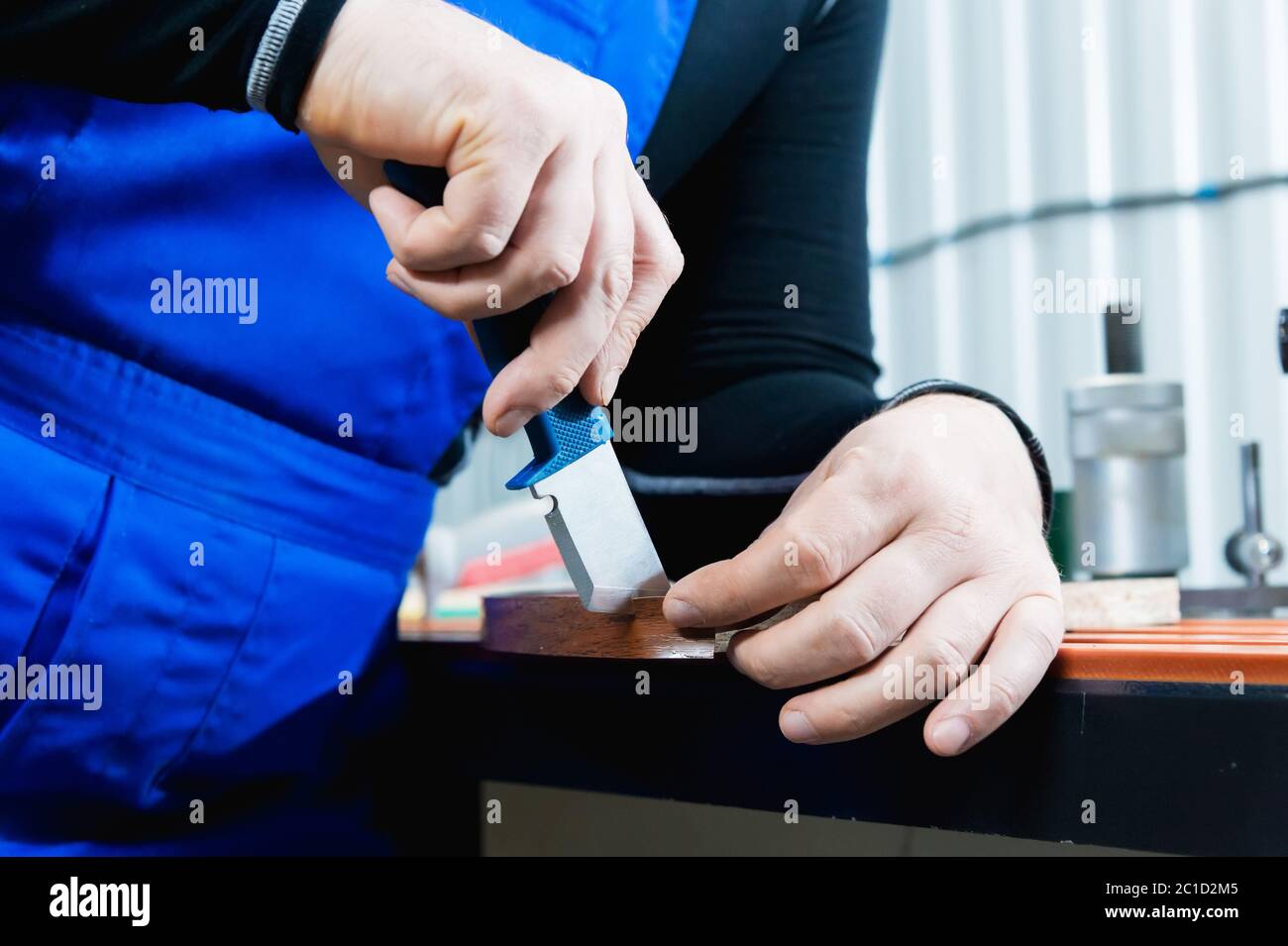 Eine Nahaufnahme der nicht gepflegten Hände des echten männlichen Zimmermanns rundet das Finish der Spanplatten-Details der Möbel ab Stockfoto