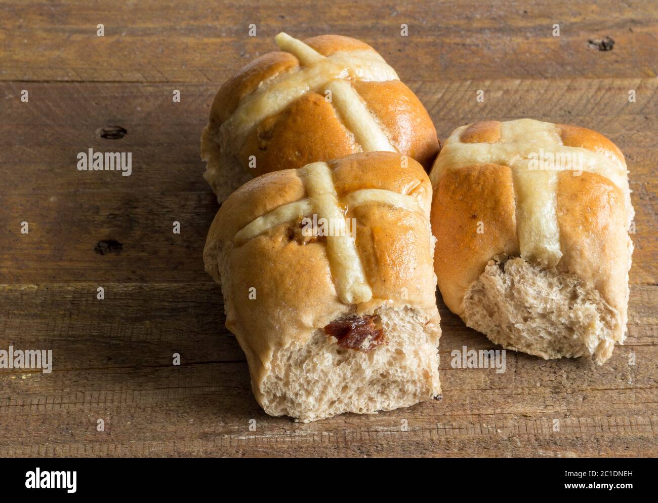 Heiße Kreuz-Brötchen auf rustikalem Holztisch aus der Nähe Stockfoto