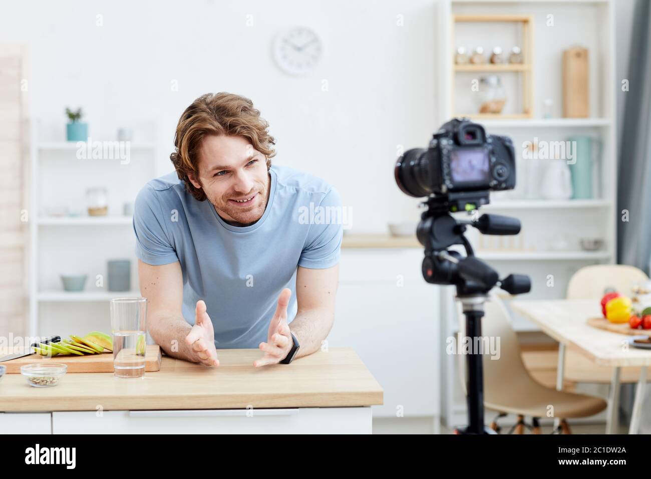 Junger Mann, der das Video dreht, das er seinen Anhängern von der gesunden Nahrung erzählt, während er in der Küche steht Stockfoto