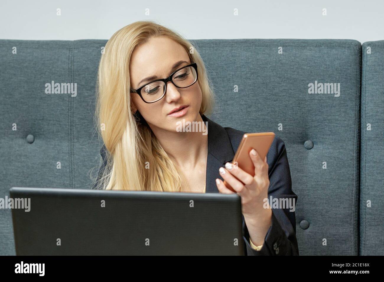 Junge Frau ist mit Smartphone sitzen am Holztisch im Café. Stockfoto