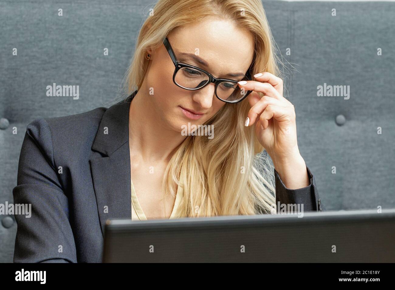 Beschäftigte Geschäftsfrau trägt Brille auf Laptop im Home Office. Stockfoto