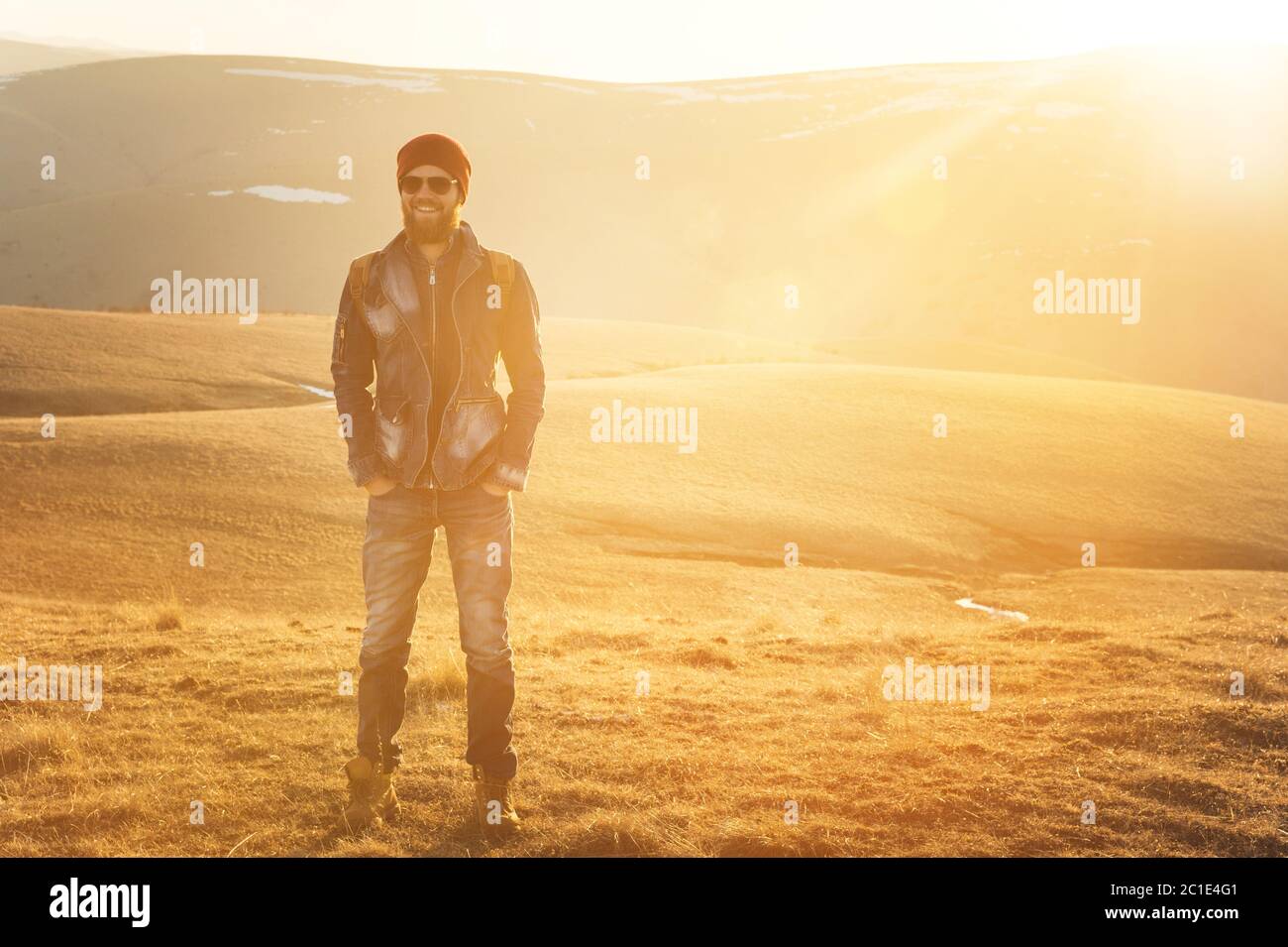Modehortrait eines bärtigen Hipster-jungen Mannes mit Sonnenbrille, Rucksack und Hut auf einem Hintergrund mit Copyspase im mou Stockfoto