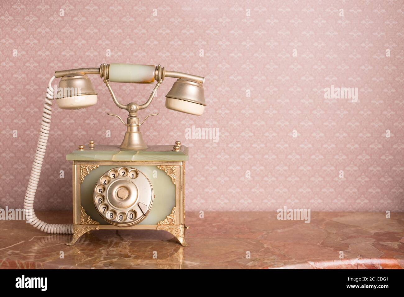 Studiofoto des retro Telefons auf dem Hintergrund der Tapete. Westeuropa Stockfoto