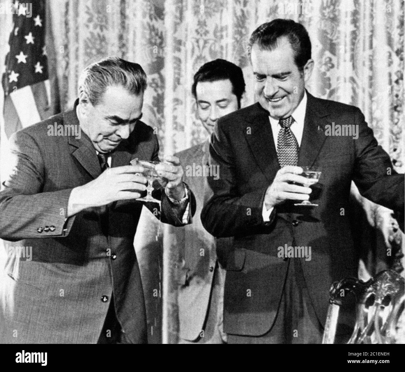 US-Präsident Nixon greift, um sein Glas mit dem von Henry Kissinger in Moskau im Jahr 1972 mit UdSSR-Führer Leonid Breschnew im Hintergrund zu klirken Stockfoto