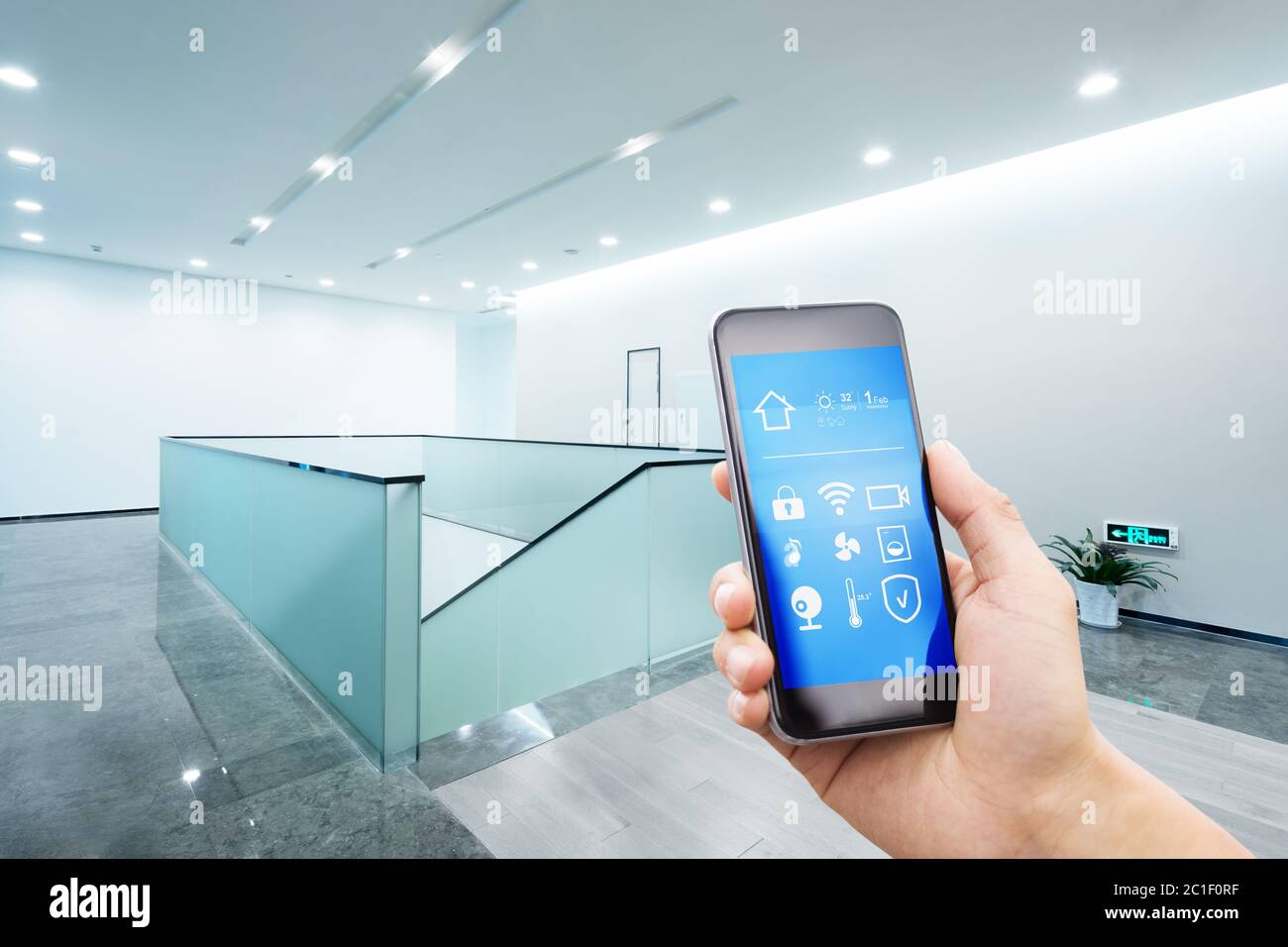 Mobiles Telefon mit Smart Home im modernen Büro Stockfoto
